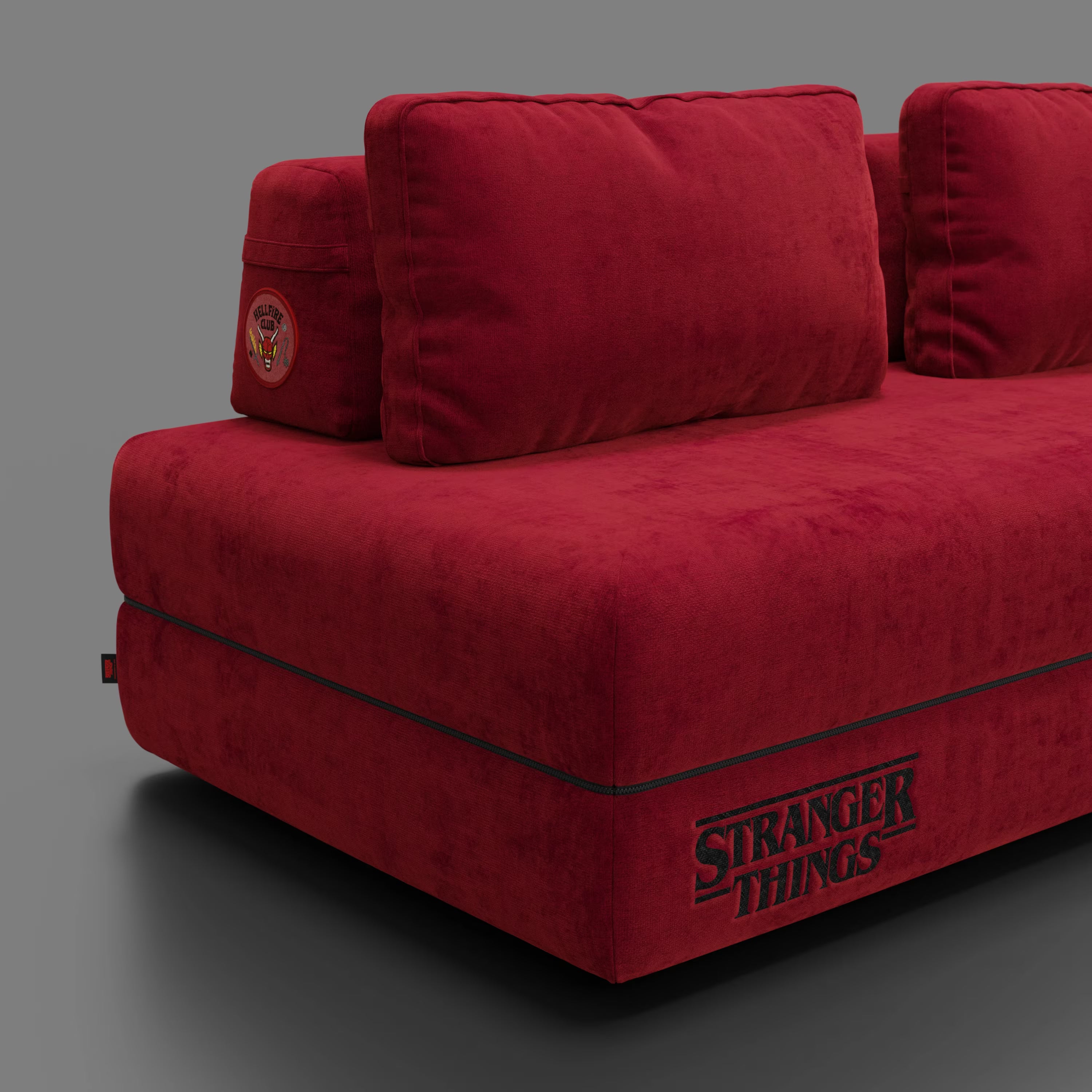 Il divano letto matrimoniale Rift STRANGER THINGS Edition di Divani.Store è caratterizzato da tessuto rosso antimacchia, schienali mobili, materasso in memory foam (22 cm) e dettagli "Stranger Things", che conferiscono uno stile Netflix a qualsiasi stanza. Sfondo grigio semplice.