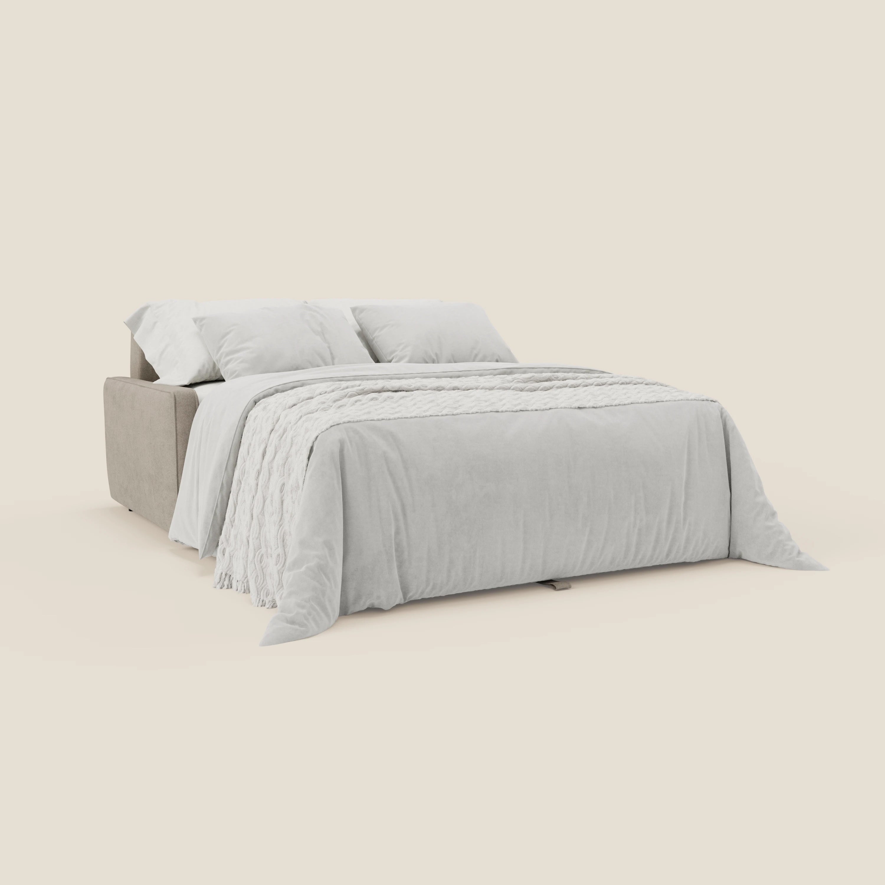 Il Nivon Divano letto moderno di Divani.Store in tessuto impermeabile beige T25 si trasforma in un letto con materasso da 16 cm di altezza, sormontato da un piumino grigio chiaro, da una coperta strutturata e da cuscini in tessuto per un comfort e uno stile moderni.