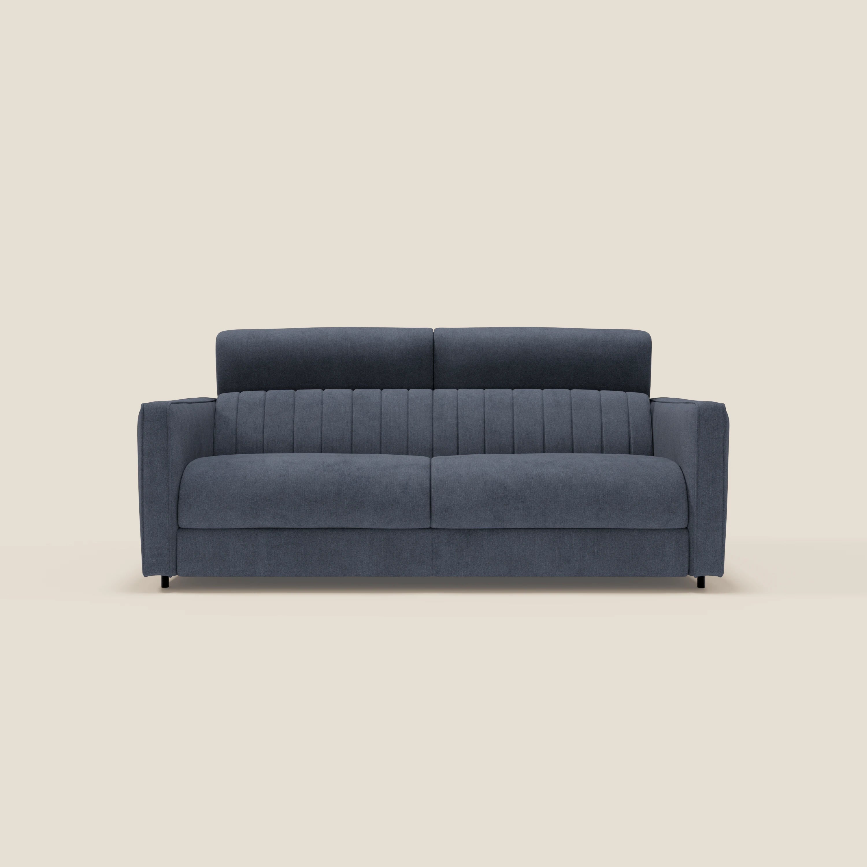 Il divano letto moderno Nivon di Divani.Store è caratterizzato da un tessuto impermeabile blu denim T25, ampi braccioli, due grandi cuscini di seduta, cuciture verticali sullo schienale, materasso da 16 cm, forma squadrata e gambe corte nere su sfondo bianco sporco.