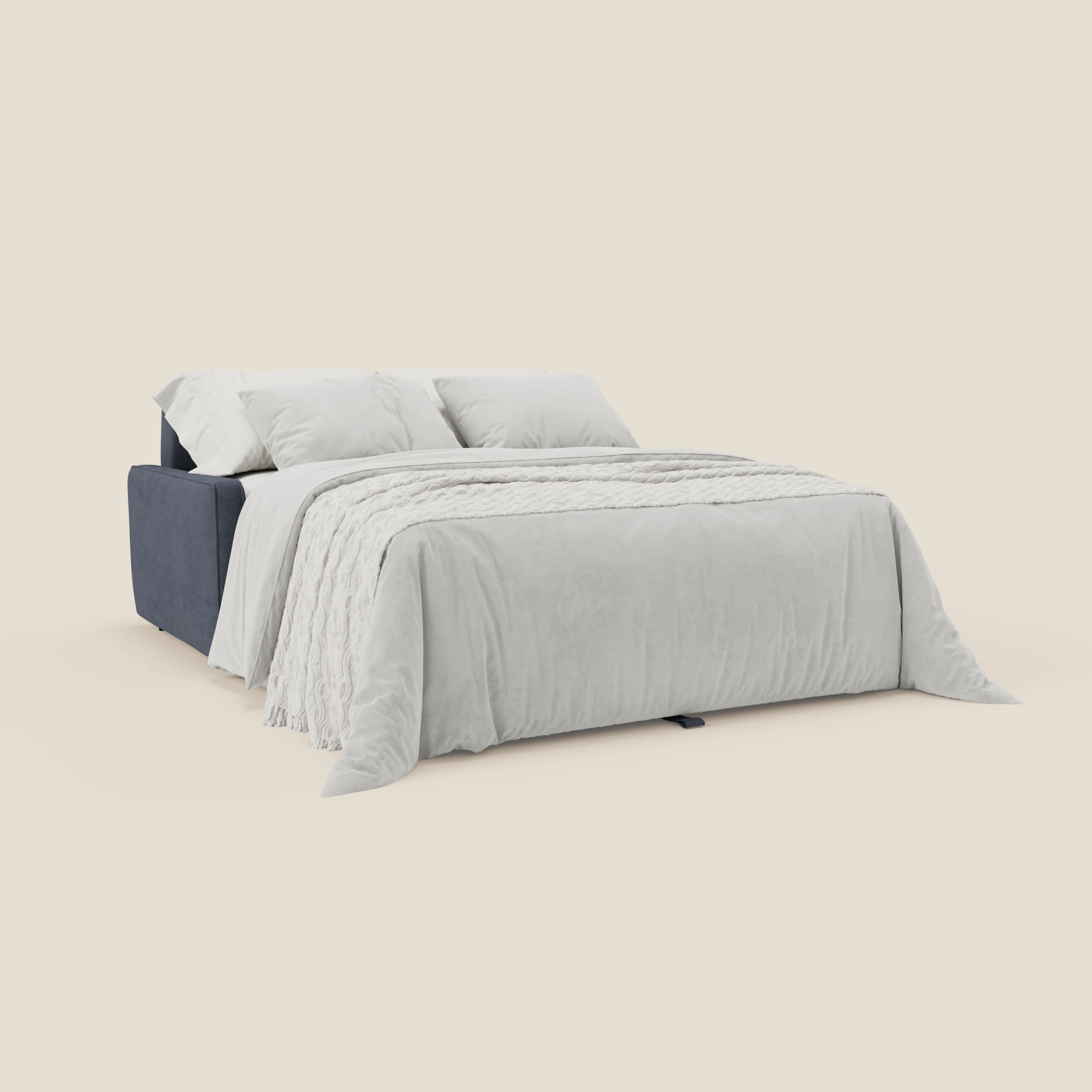 Il divano letto moderno Nivon di Divani.Store in T25 blu denim è composto da un piumone grigio chiaro, cuscini coordinati e una coperta bianca, il tutto su uno sfondo bianco sporco per un look elegante.