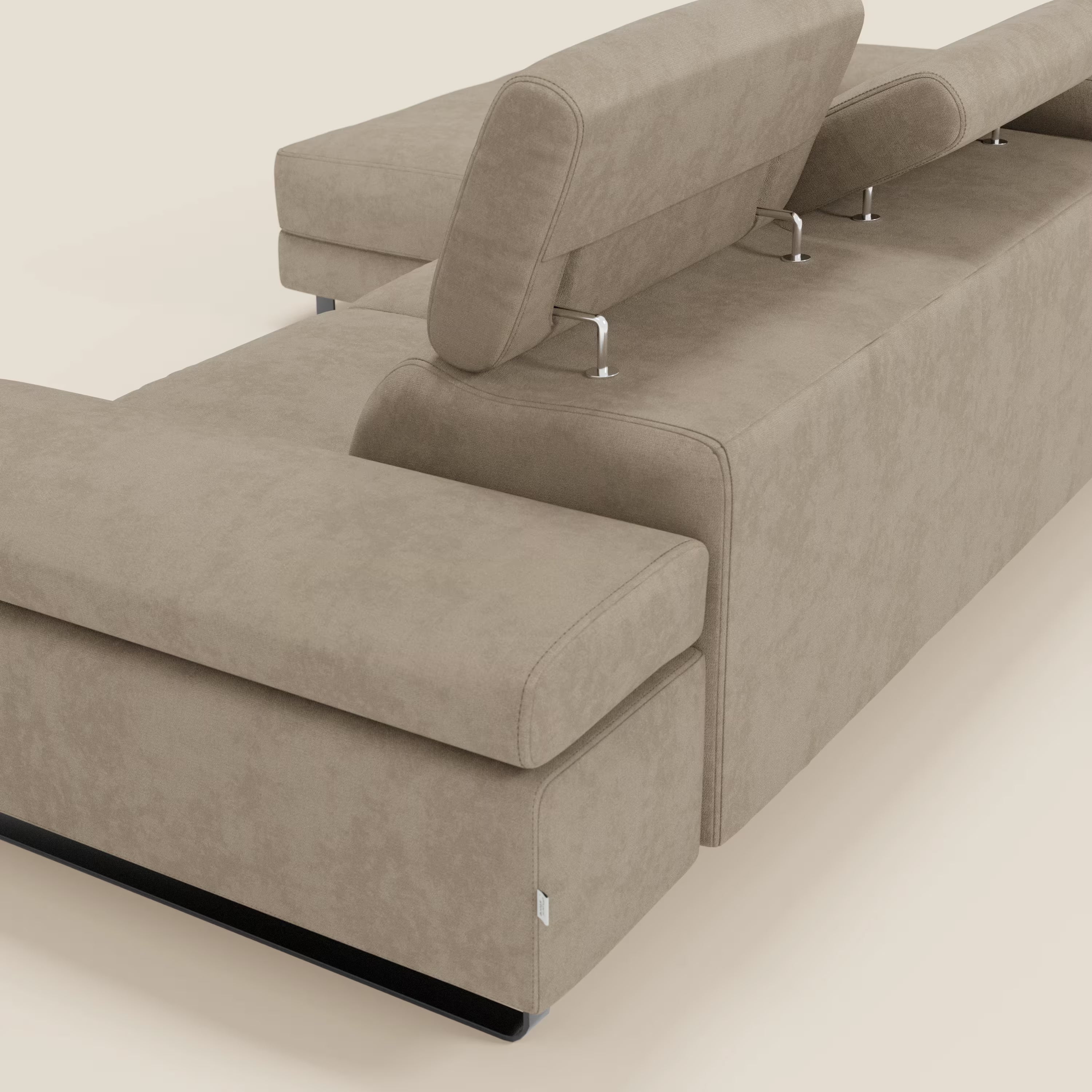 Il divano angolare estraibile Zayana di Divani.Store è caratterizzato da braccioli e poggiatesta regolabili in tessuto impermeabile T02 beige. Le sue linee pulite e il design minimale spiccano su uno sfondo bianco sporco.