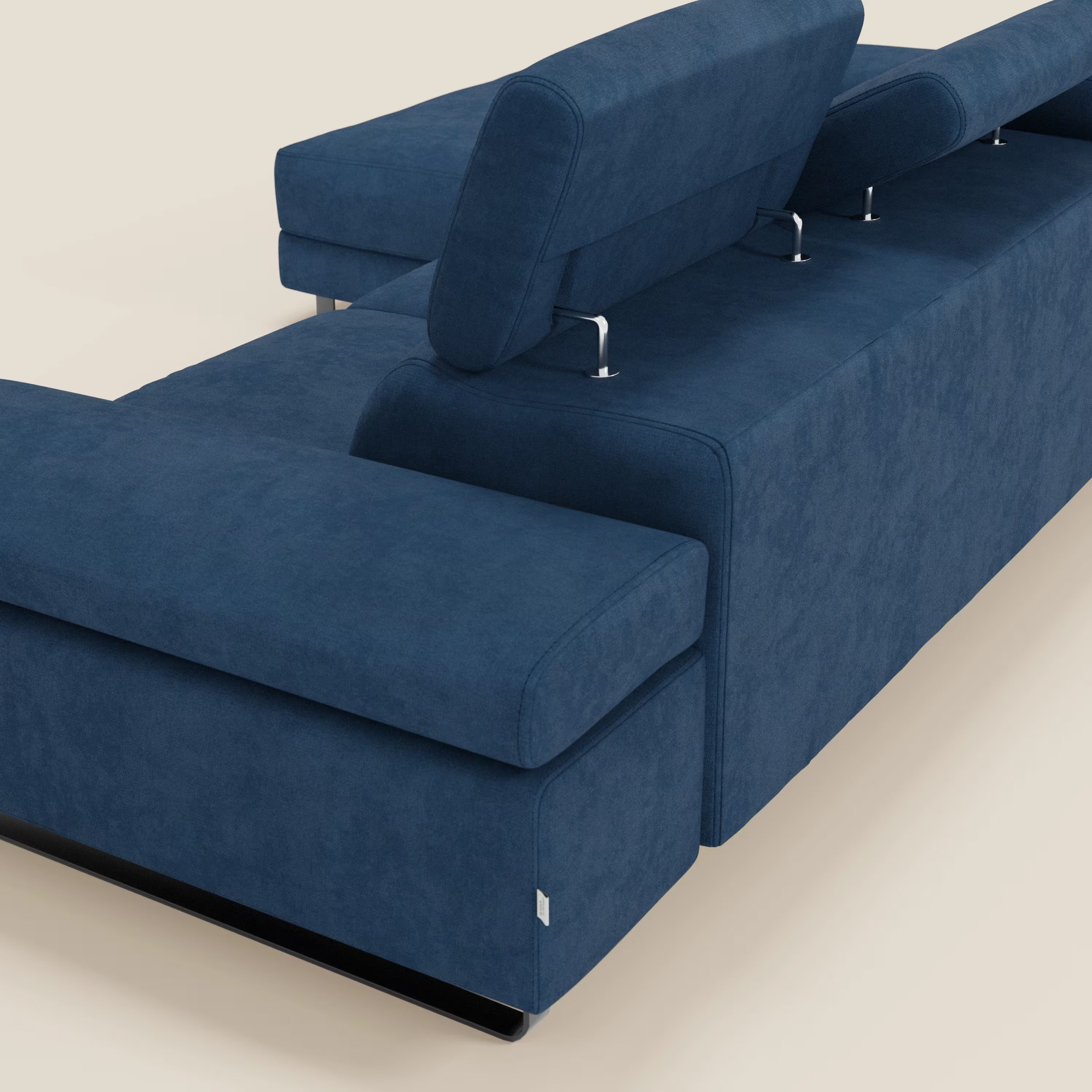 Il divano angolare estraibile Zayana di Divani.Store, visto da dietro in posizione angolare, è caratterizzato da braccioli e poggiatesta reclinabili e dal morbido tessuto impermeabile T02 blu, per un look elegante e minimalista su uno sfondo semplice.