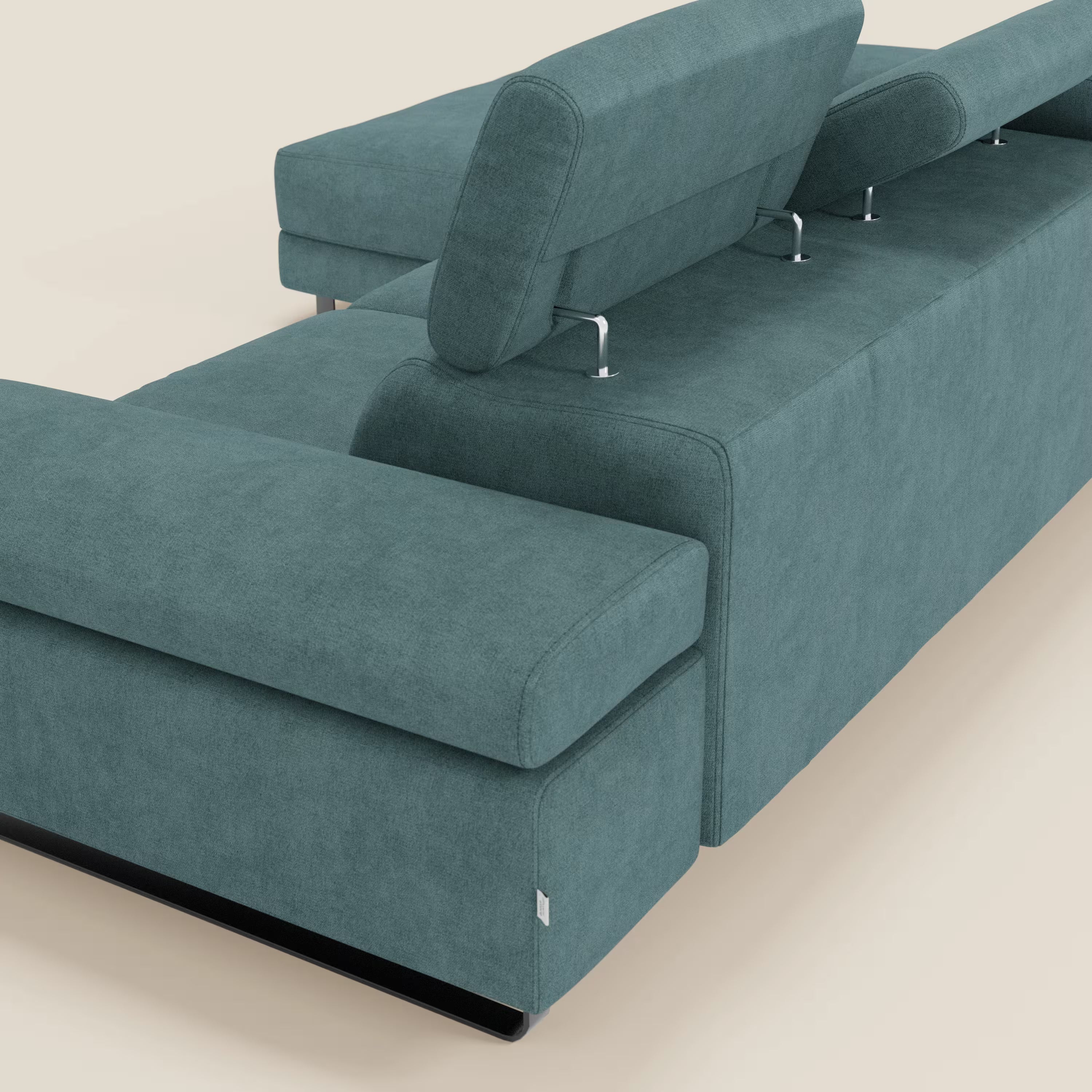 Il divano angolare estraibile Zayana di Divani.Store in tessuto impermeabile T02 petrolio è caratterizzato da ampi braccioli, poggiatesta reclinabili con supporti in metallo e una base bassa di colore nero, mostrata angolata per evidenziare lo schienale e il bracciolo su uno sfondo chiaro.