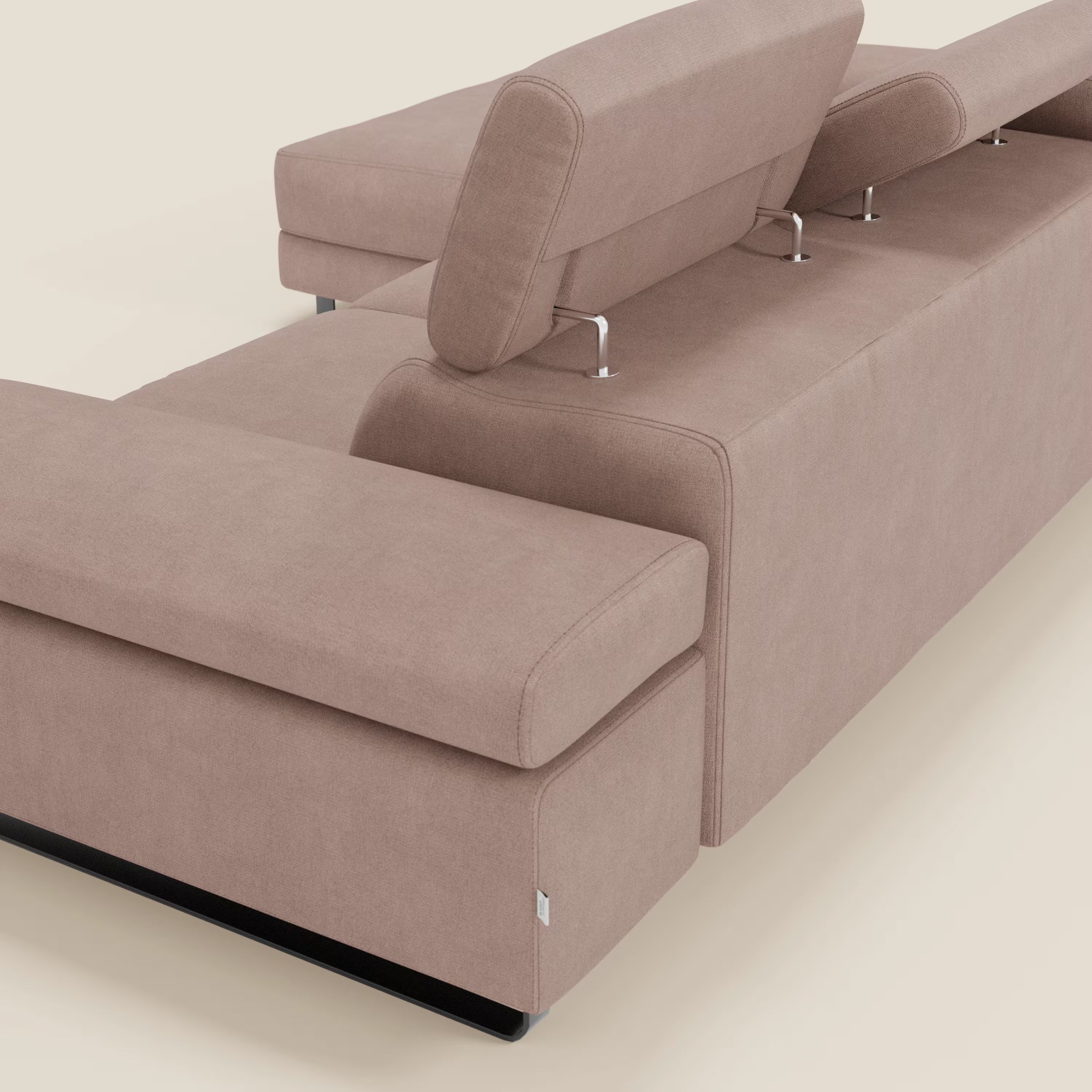 Il divano angolare estraibile Zayana di Divani.Store, nella vista posteriore angolare, è caratterizzato da braccioli e poggiatesta reclinabili in tessuto impermeabile T02 rosa e da un design pulito e contemporaneo su uno sfondo bianco sporco.