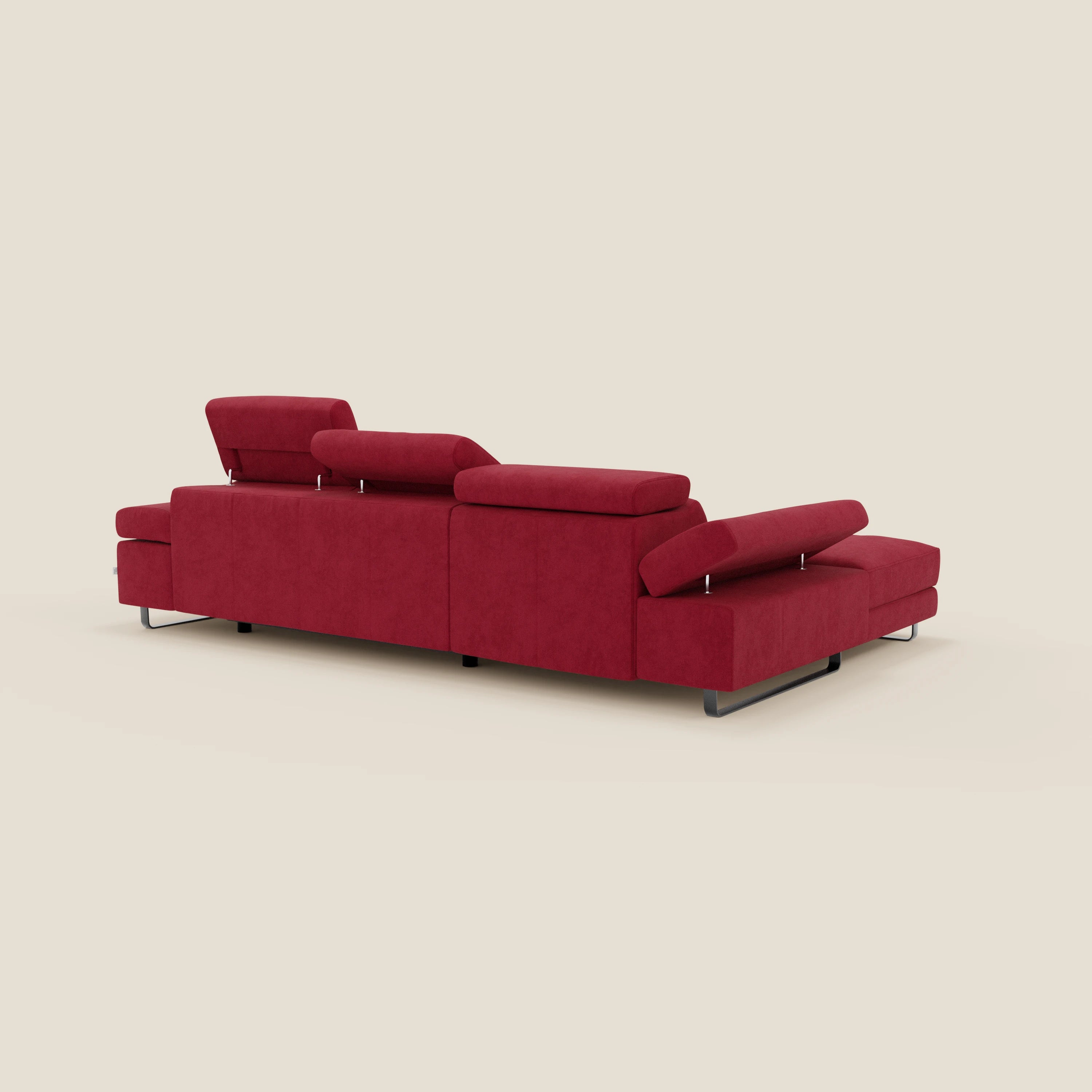 Il divano angolare estraibile Zayana di Divani.Store è presentato da un punto di vista angolare, con tessuto impermeabile rosso T02, braccioli e poggiatesta regolabili, linee pulite, cuscini morbidi e gambe sottili in metallo nero su uno sfondo beige.