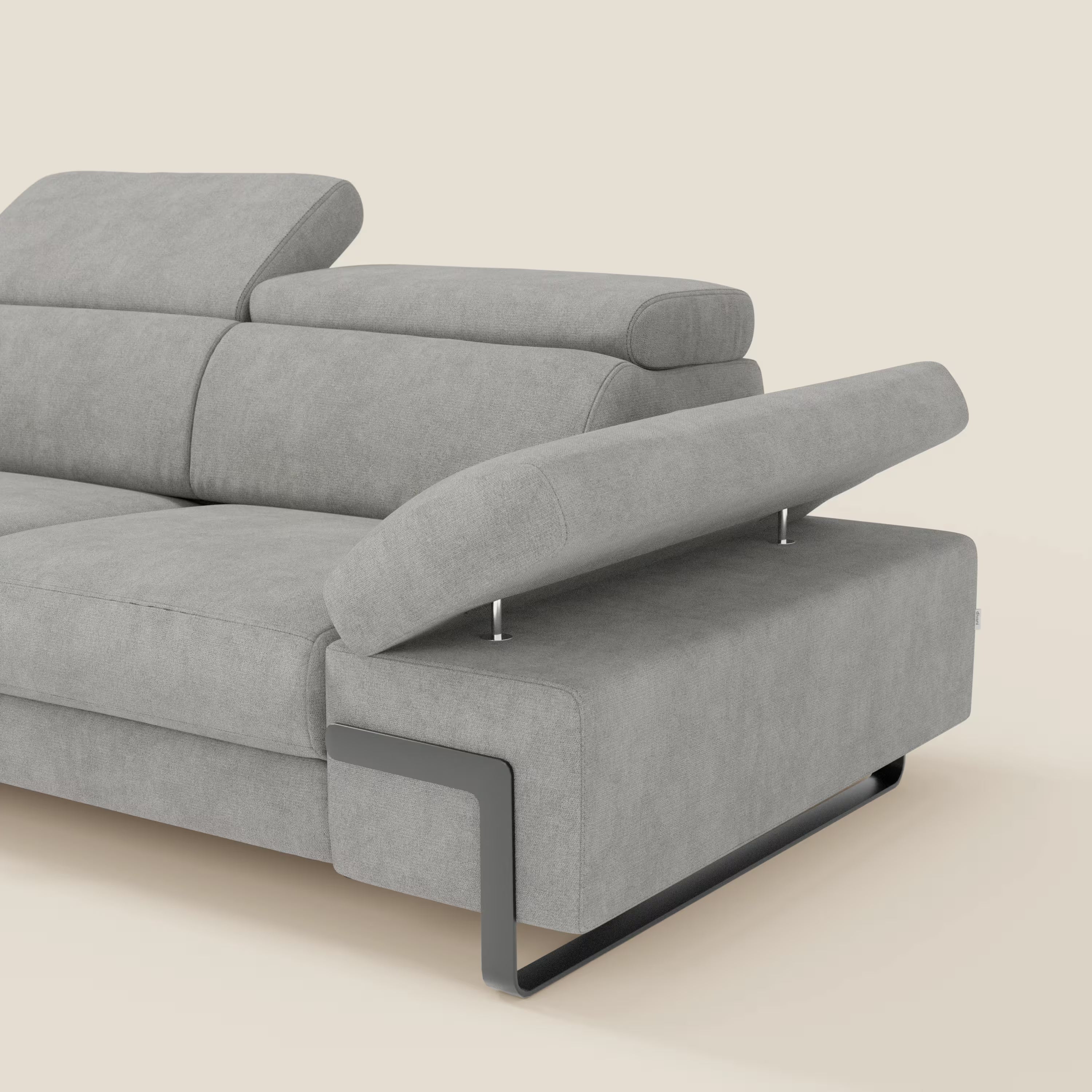 Zayana Divano 3 posti di Divani.Store è caratterizzato da braccioli e poggiatesta regolabili, elemento estraibile, tessuto impermeabile T02 grigio chiaro e gambe minimaliste in metallo. Il bracciolo è inclinato per mostrare il meccanismo di reclinazione su uno sfondo beige.