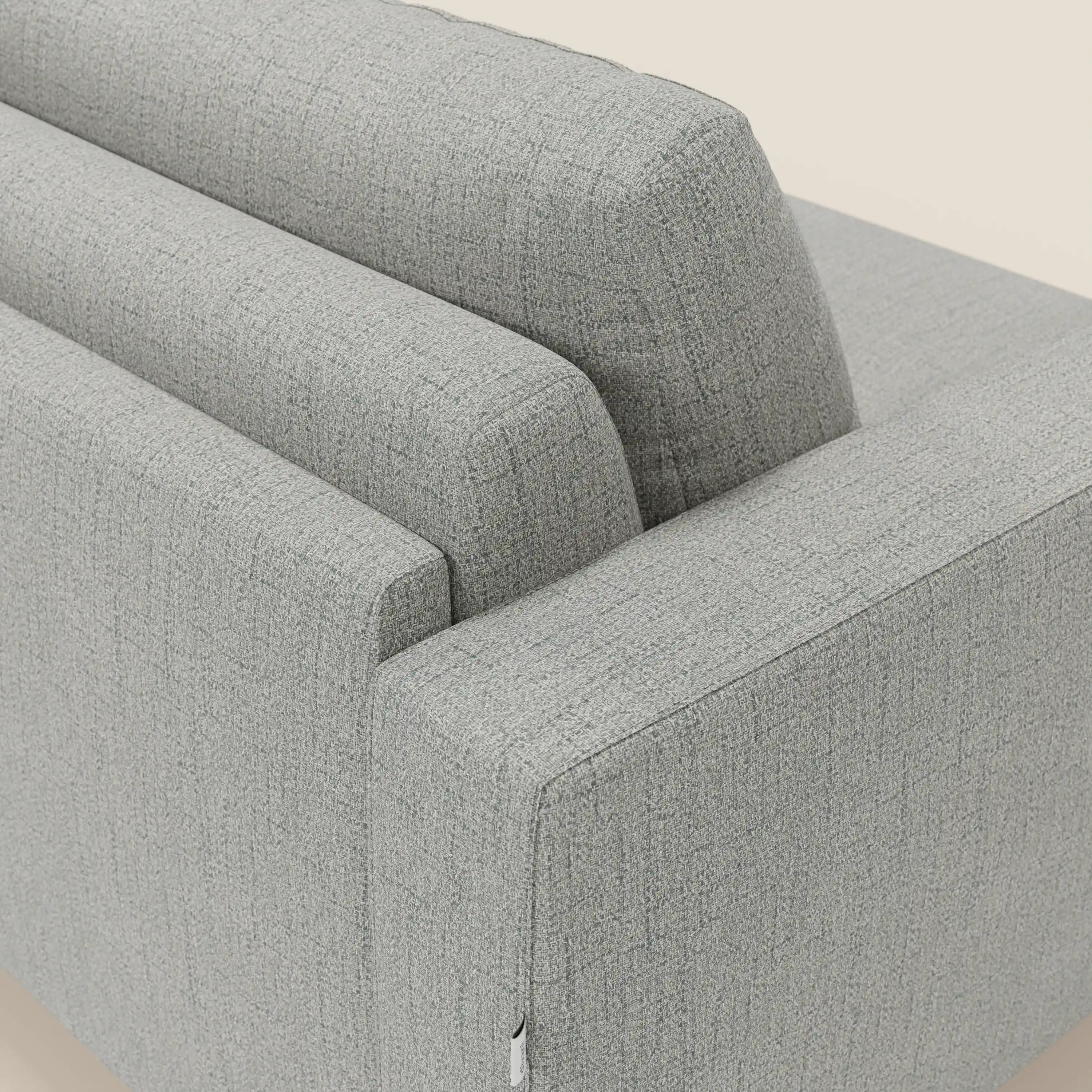 Un primo piano del divano letto matrimoniale Alaya di Divani.Store in tessuto impermeabile T03 grigio chiaro mostra le sue linee pulite, i cuscini morbidi e il design versatile su uno sfondo bianco sporco.