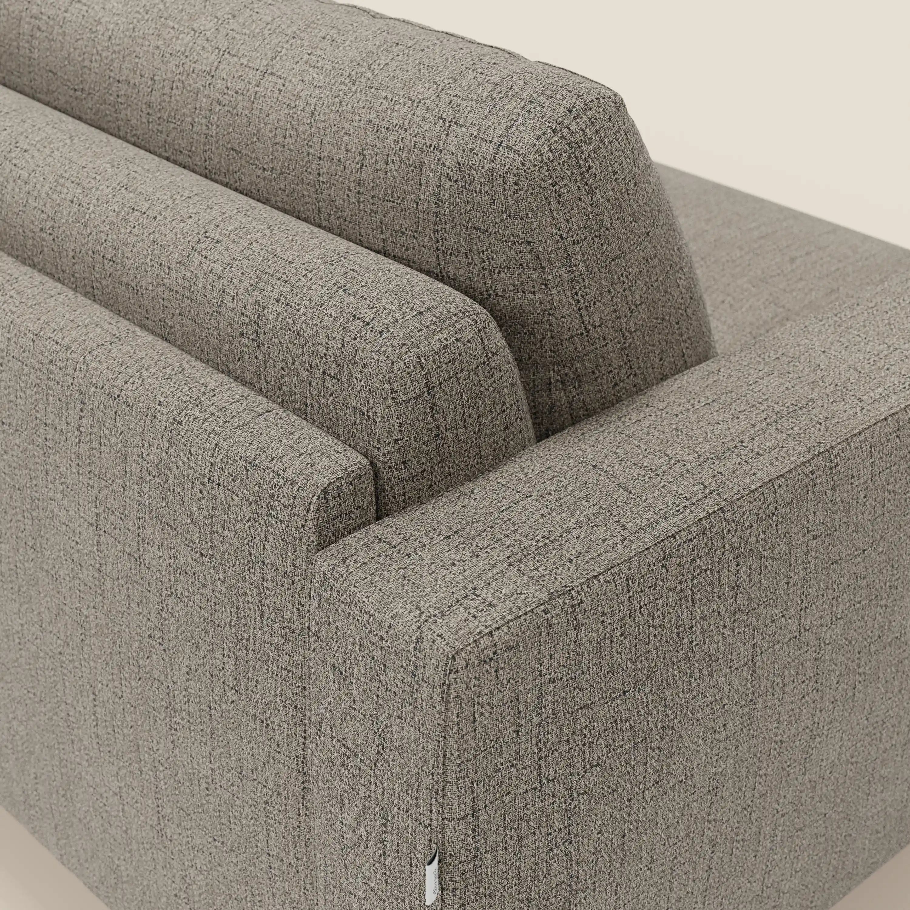 Primo piano del letto matrimoniale Alaya Divano di Divani.Store, caratterizzato da morbidi cuscini in tessuto impermeabile T03 talpa. Lo sfondo neutro ne evidenzia le linee pulite e squadrate e il design minimale.