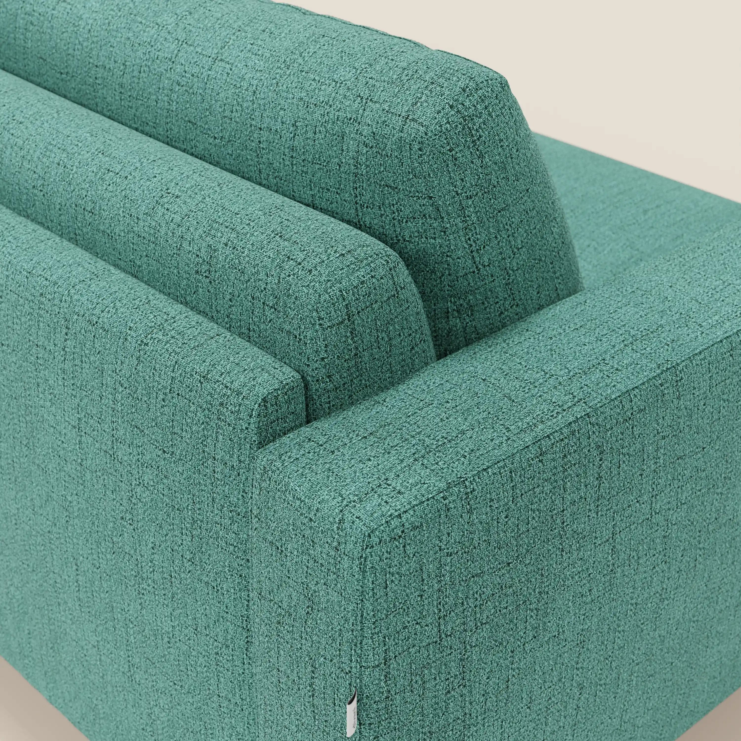 Un primo piano del divano letto matrimoniale Alaya di Divani.Store mostra il tessuto T03 verde acqua impermeabile, la trama e i morbidi cuscini, che mettono in risalto il design minimale e contemporaneo su uno sfondo beige chiaro.