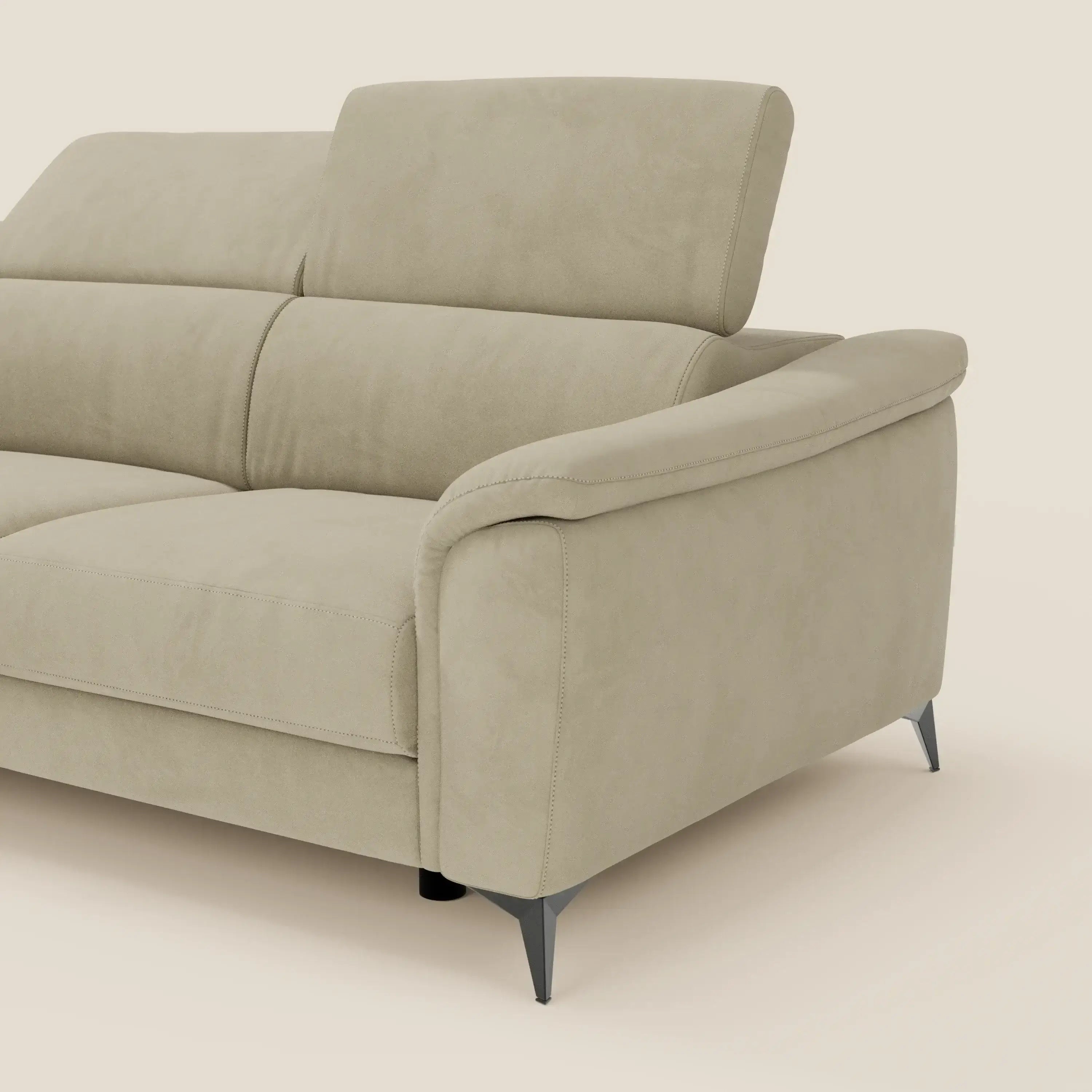 L'Arcos Divano angolare di Divani.Store è presentato in microfibra impermeabile beige, con piedini alti e poggiatesta regolabili. Su uno sfondo color crema sono visibili solo il lato destro e parte della seduta.