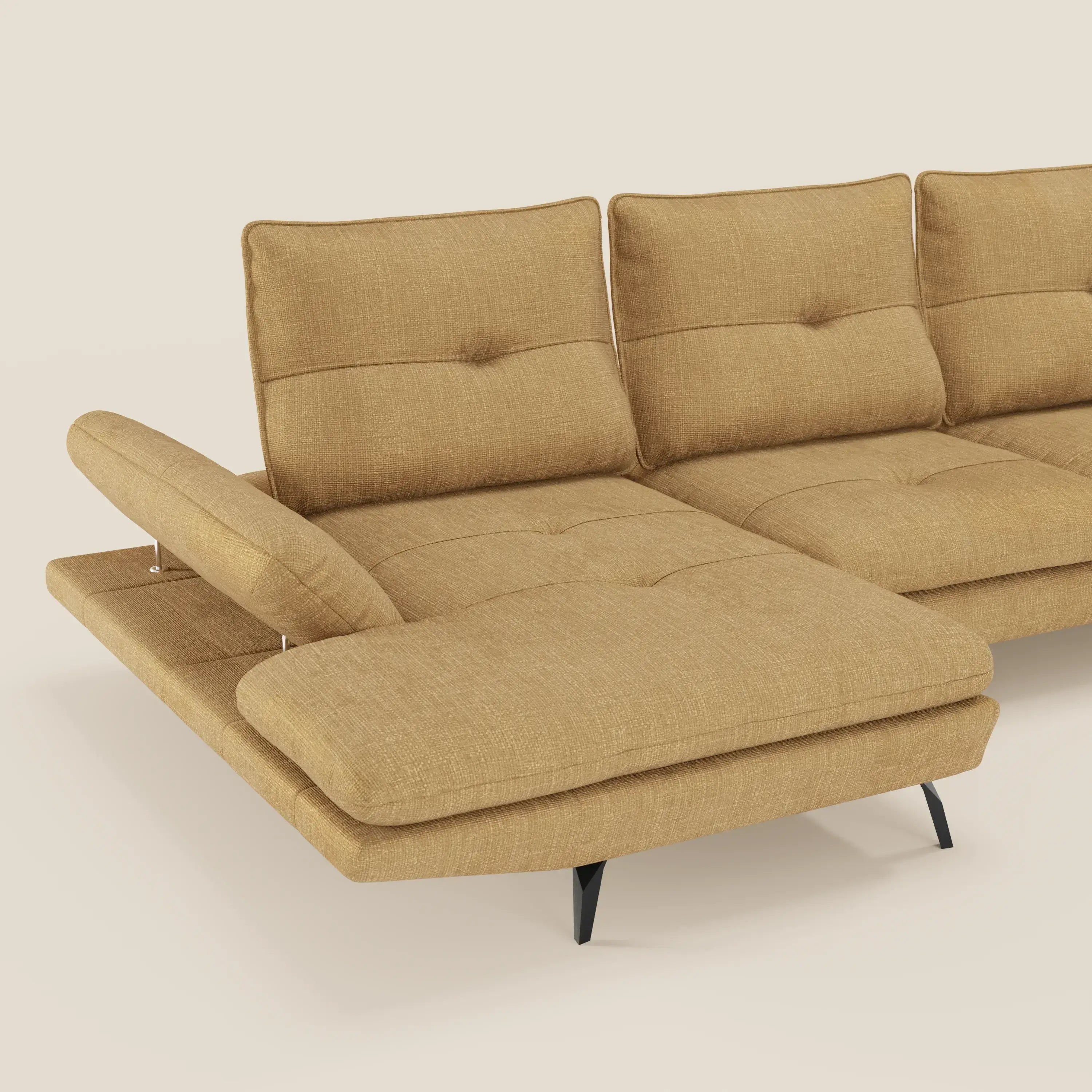 Il Divano con penisola Ardex di Divani.Store in tessuto impermeabile T06 giallo senape è caratterizzato da tre schienali trapuntati, schienali traslanti e braccioli regolabili. Si regge su gambe angolate nere su uno sfondo beige chiaro.