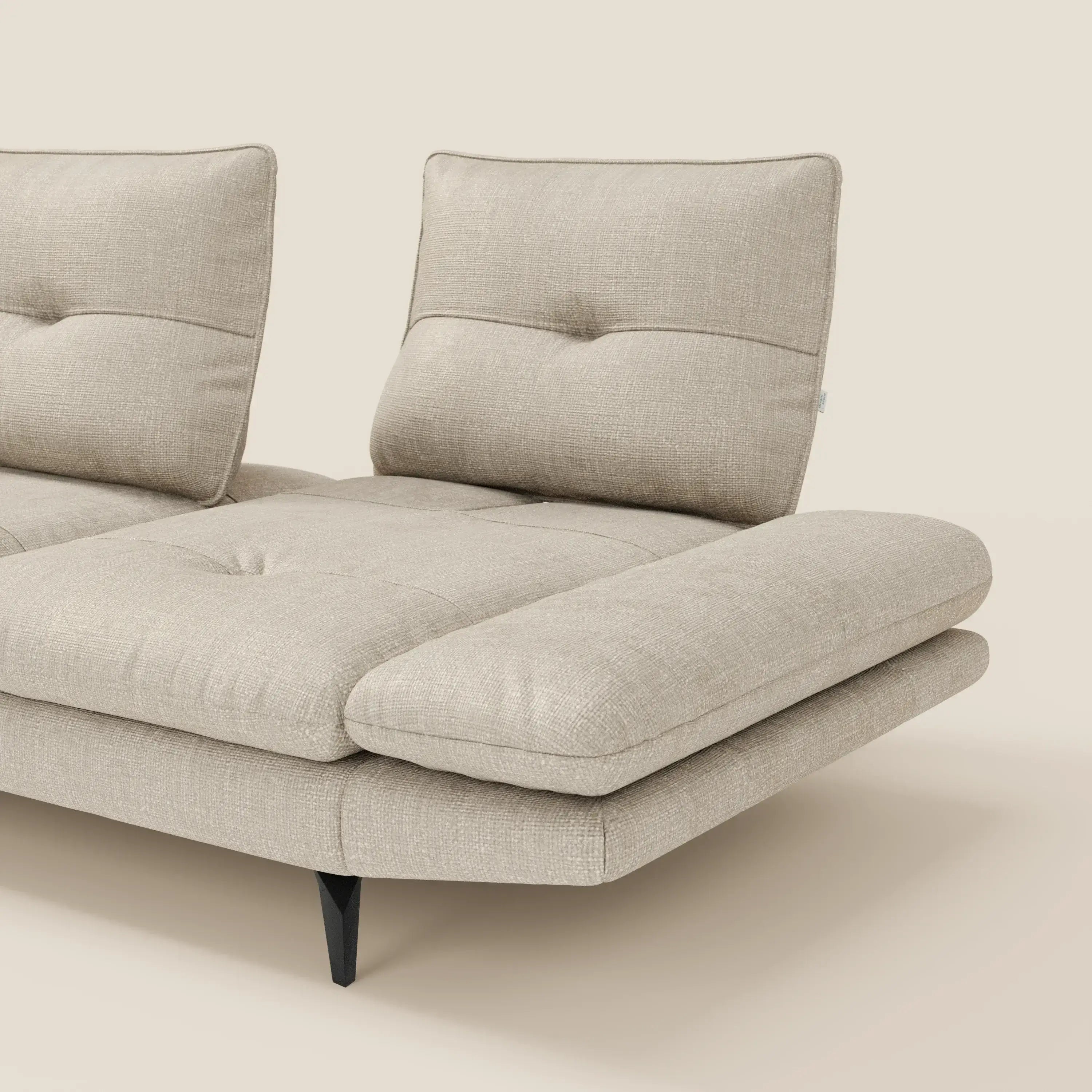 Il Divano con penisola Ardex di Divani.Store è caratterizzato da schienali traslanti, braccioli regolabili e cuscini in elegante tessuto impermeabile T06 panna, appoggiati su gambe angolate in metallo nero per un tocco moderno.