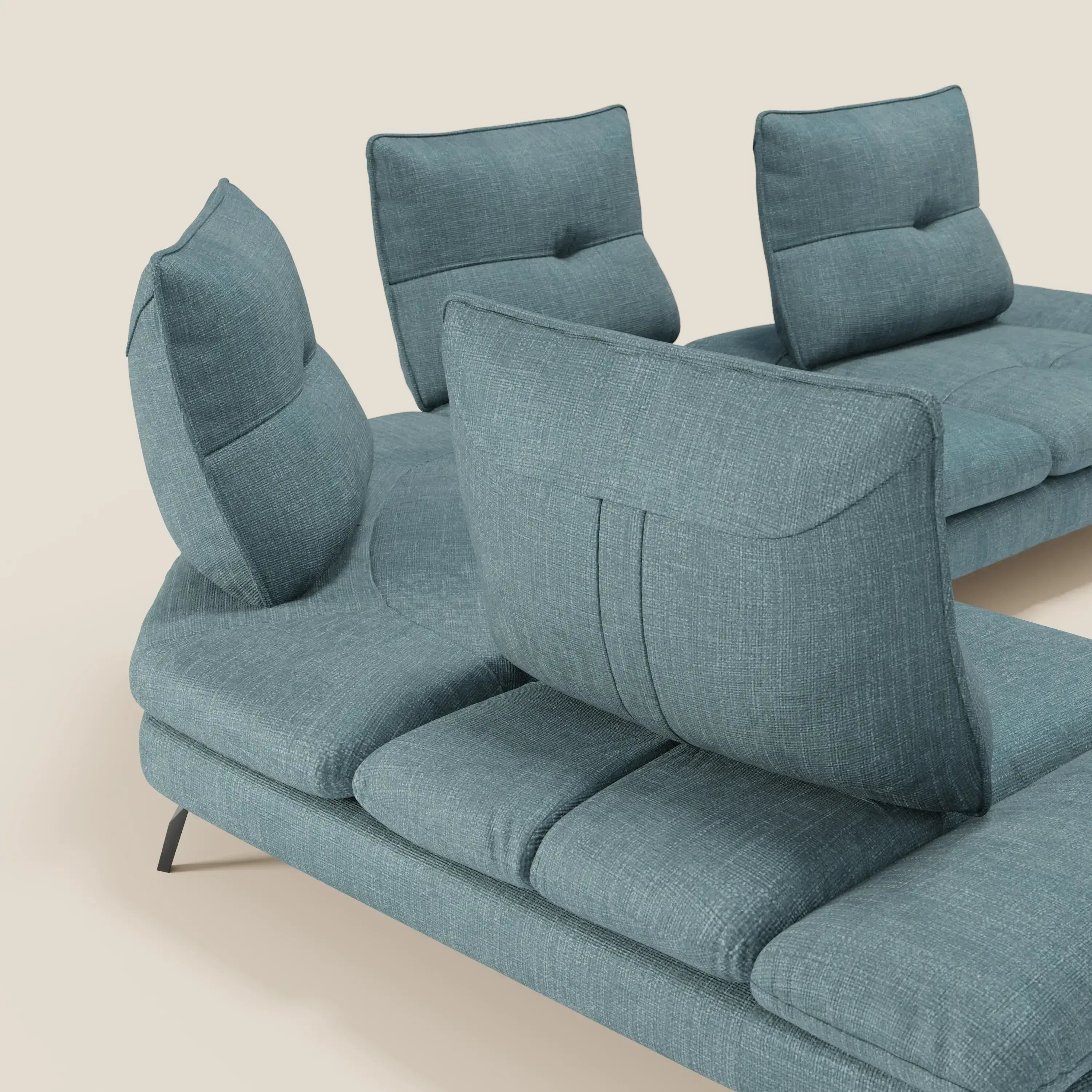 Il Divano Angolare Ardex di Divani.Store è caratterizzato da schienali traslanti e bracciolo regolabile in elegante tessuto impermeabile T06 azzurro, con sottili gambe angolari in metallo nero e stile minimalista, su sfondo beige chiaro.