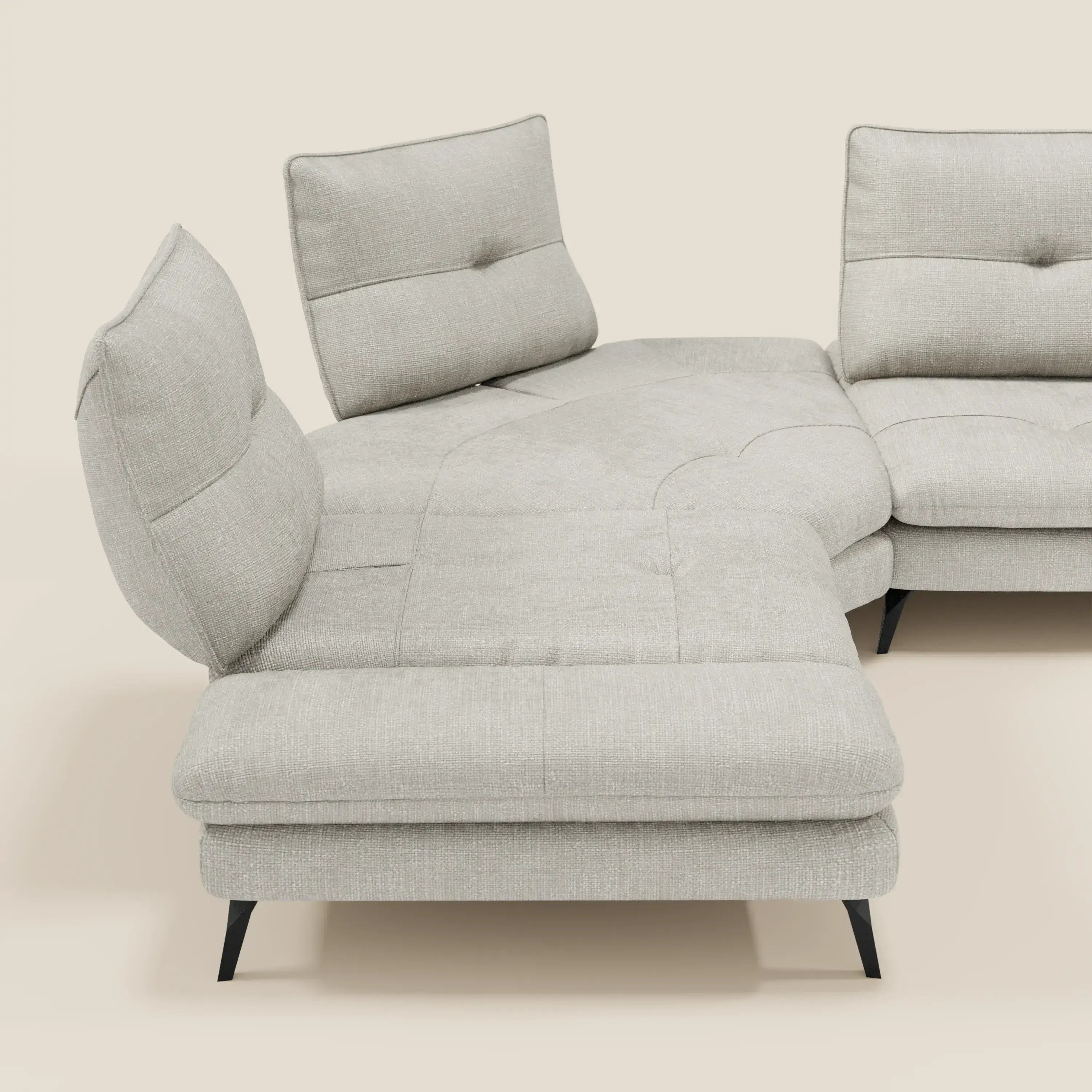 L'Ardex Divano Angolare di Divani.Store è caratterizzato da schienali traslanti, bracciolo regolabile ed elegante tessuto impermeabile T06 grigio chiaro per un look moderno, su sfondo bianco sporco.