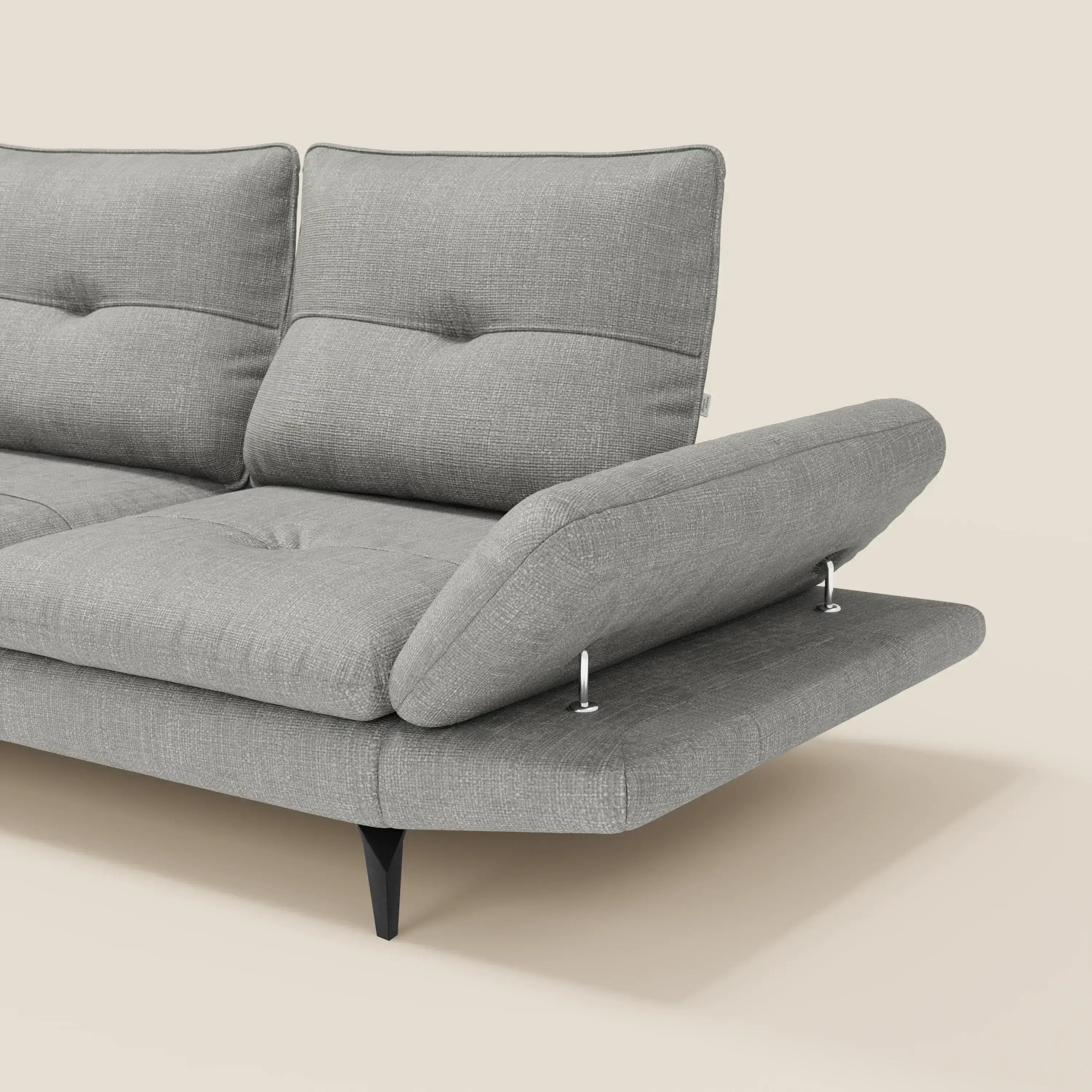 L'Ardex Divano Angolare di Divani.Store, presentato in un elegante tessuto impermeabile grigio T06 con schienale scorrevole e bracciolo regolabile, è caratterizzato da cuscini trapuntati e gambe angolari nere su uno sfondo beige chiaro.