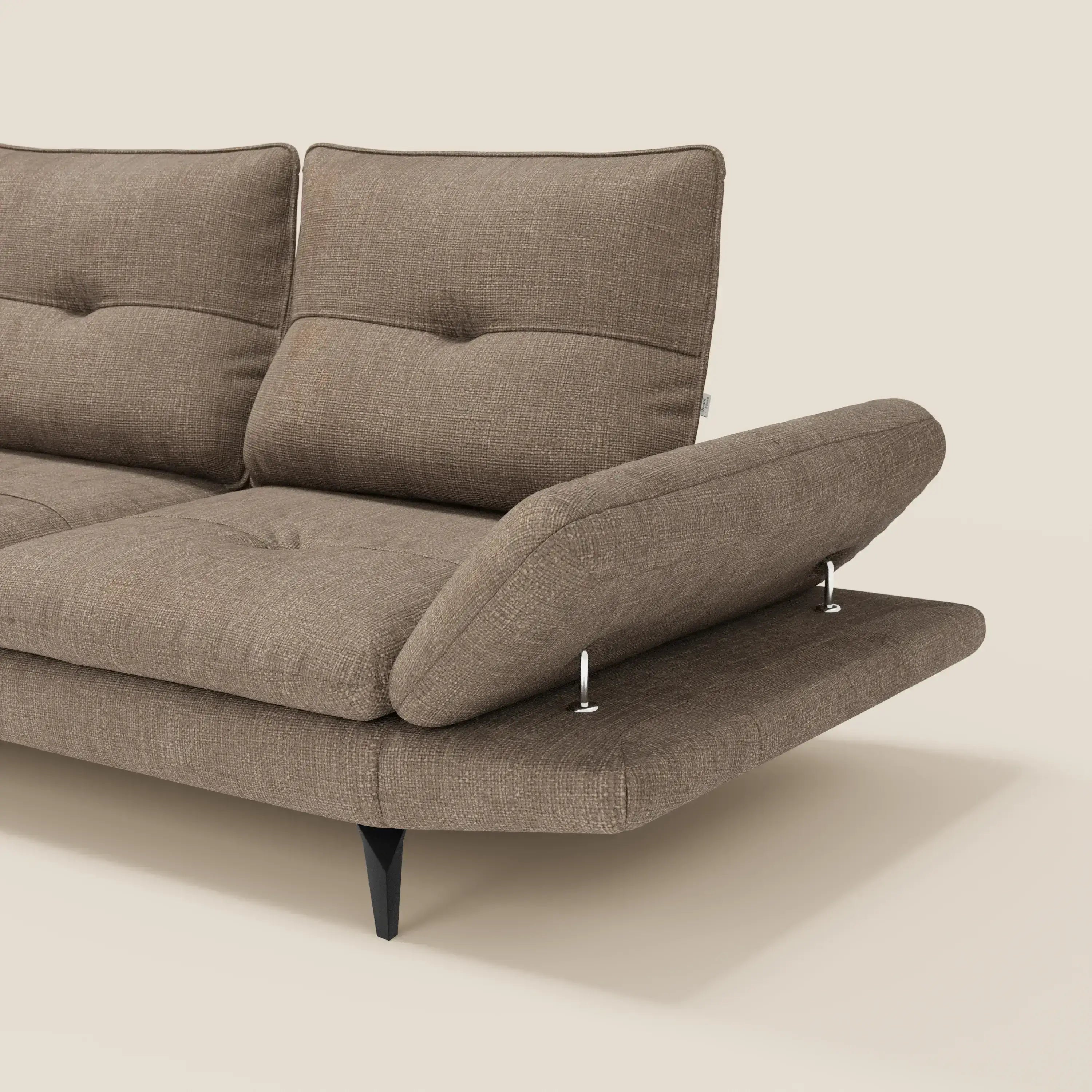 L'Ardex Divano Angolare di Divani.Store in tessuto impermeabile marrone T06 è caratterizzato da schienale scorrevole, bracciolo flessibile e regolabile con supporti in metallo, cuscini imbottiti e gambe affusolate nere su sfondo beige chiaro. Solo una parte è visibile.