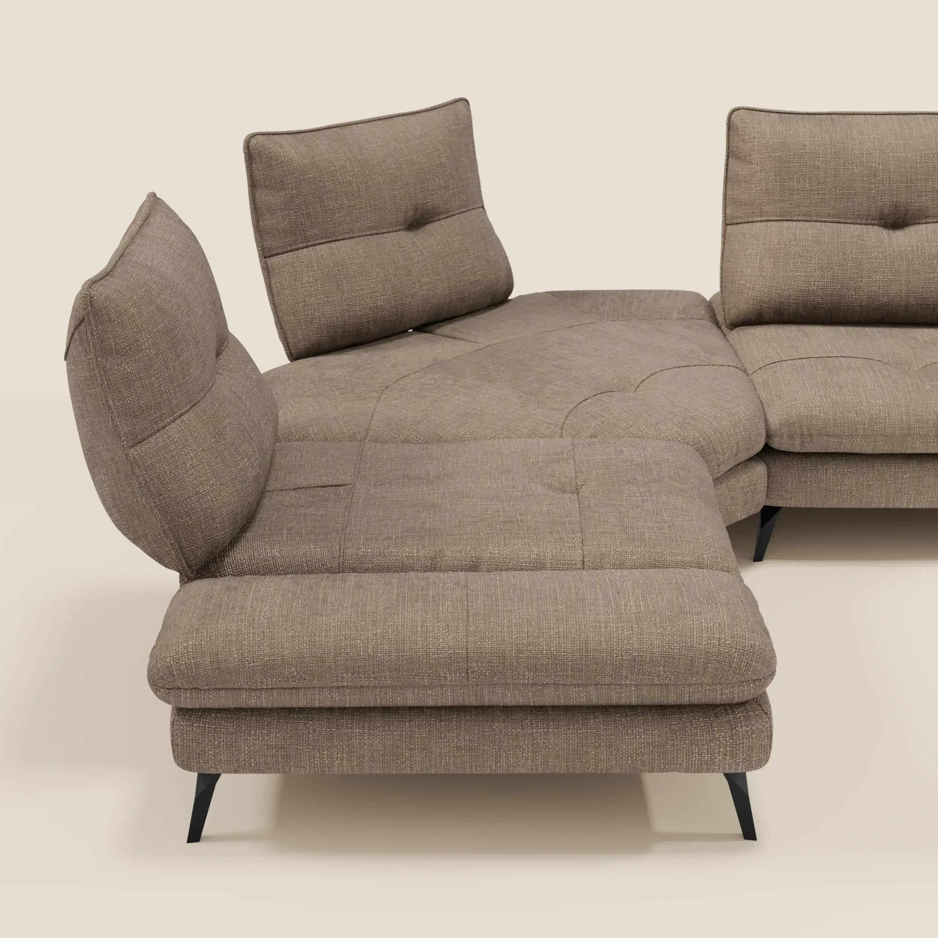 Ardex Divano Angolare di Divani.Store è caratterizzato da tre schienali traslanti, un bracciolo regolabile, gambe nere angolate ed elegante tessuto impermeabile T06 marrone con cuscini trapuntati su uno sfondo beige chiaro.