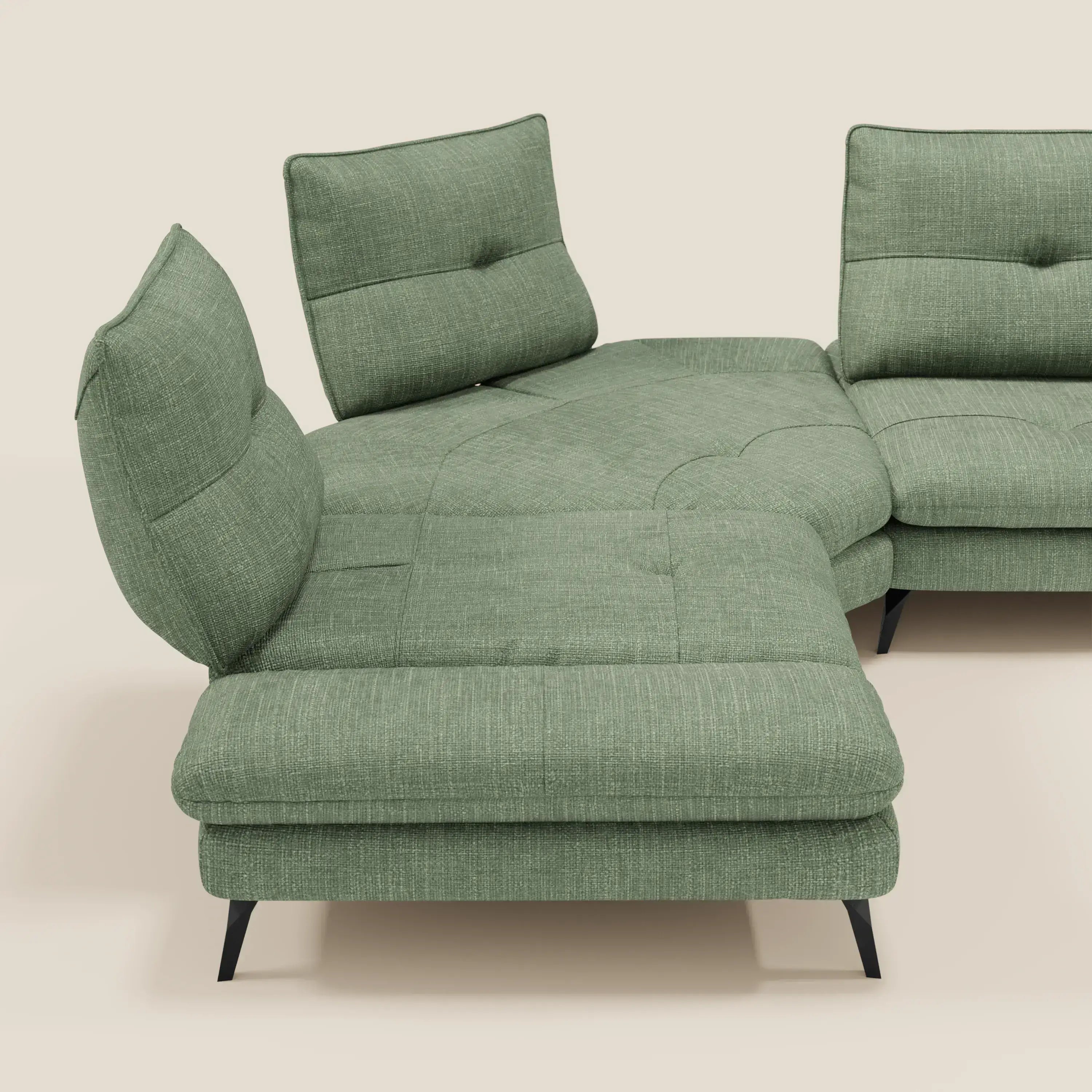 L'Ardex Divano Angolare di Divani.Store è caratterizzato da schienali traslanti, bracciolo regolabile e cuscini trapuntati in elegante tessuto impermeabile verde T06 con sottili gambe in metallo nero, il tutto accentuato da uno sfondo neutro.