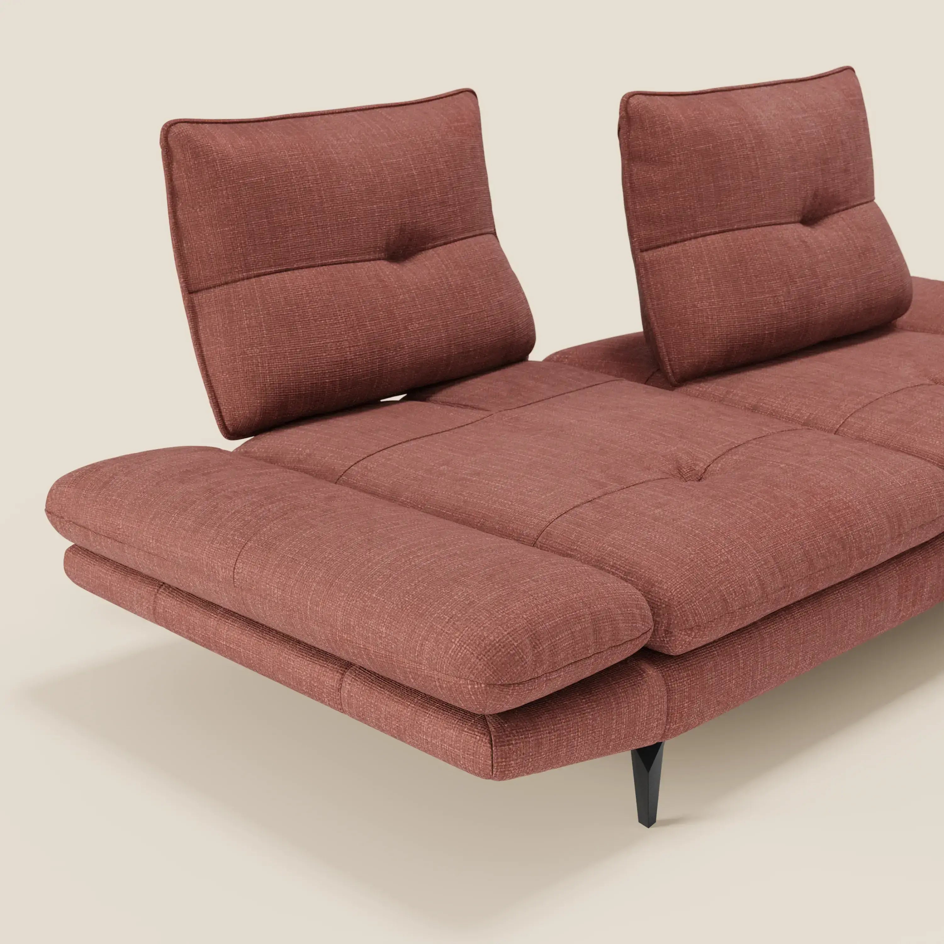 Ardex Divano 3 posti di Divani.Store, presentato in tessuto impermeabile T06 corallo, è caratterizzato da schienali traslanti, braccioli regolabili per il comfort personale, sottili imbottiture e sottili gambe nere su sfondo beige.