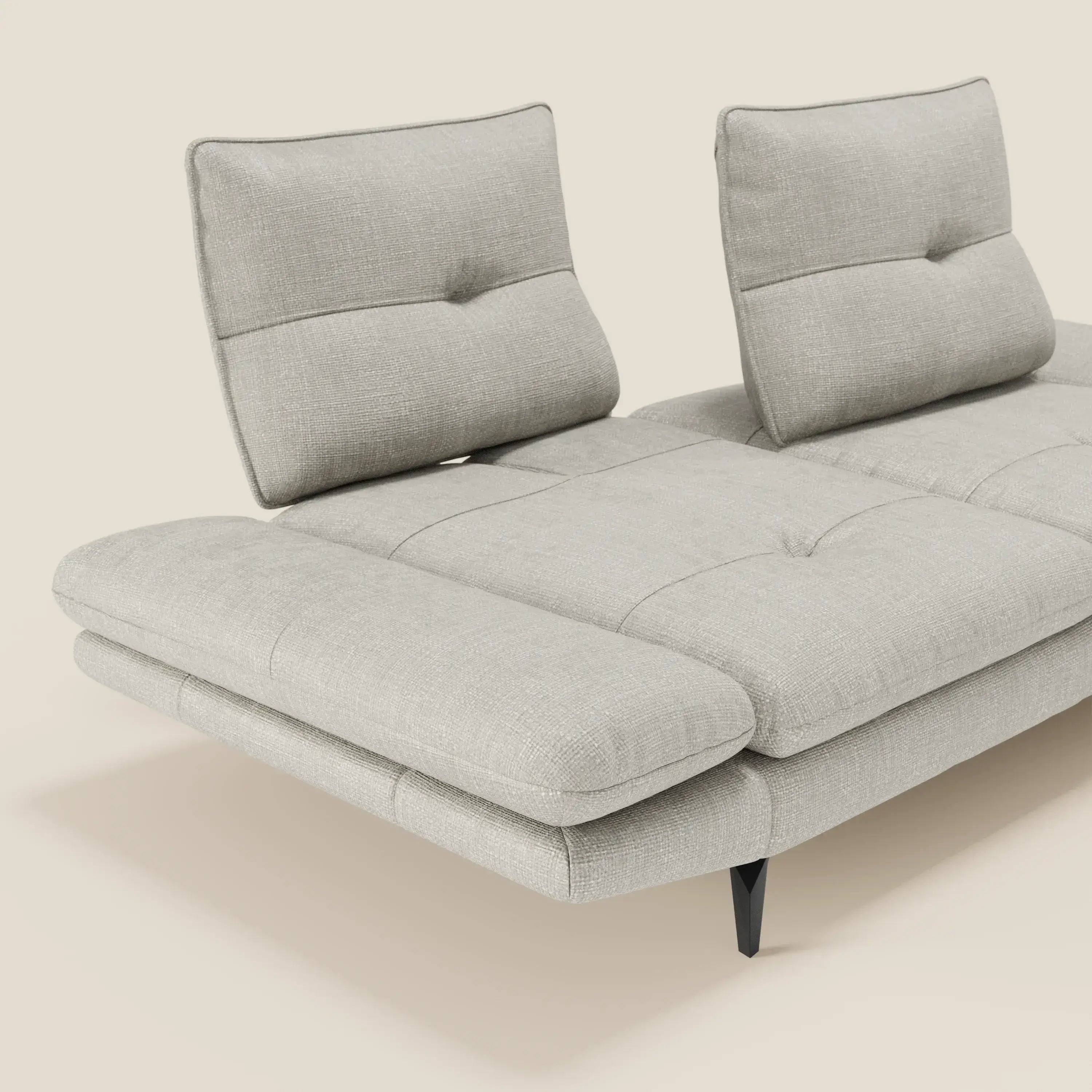 Ardex Divano 3 posti di Divani.Store è caratterizzato da schienali traslanti, braccioli regolabili e da un'ampia seduta in morbido tessuto impermeabile T06 grigio chiaro con gambe angolari nere, presentate su sfondo beige in uno stile minimalista.