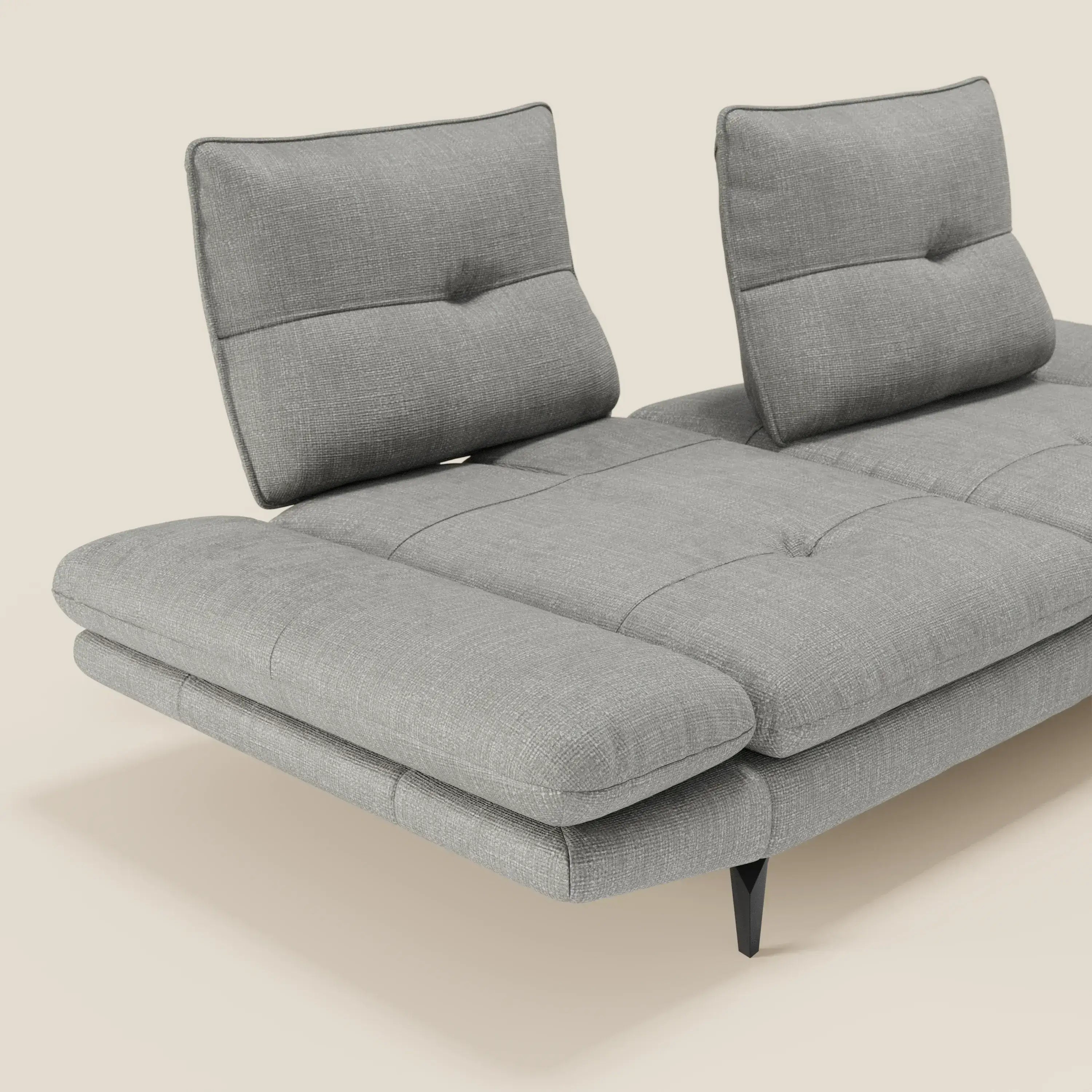 Ardex Divano 3 posti di Divani.Store, in morbido tessuto impermeabile grigio T06, è caratterizzato da schienali scorrevoli e braccioli regolabili, seduta trapuntata e sottili gambe angolari nere, il tutto su uno sfondo beige chiaro.