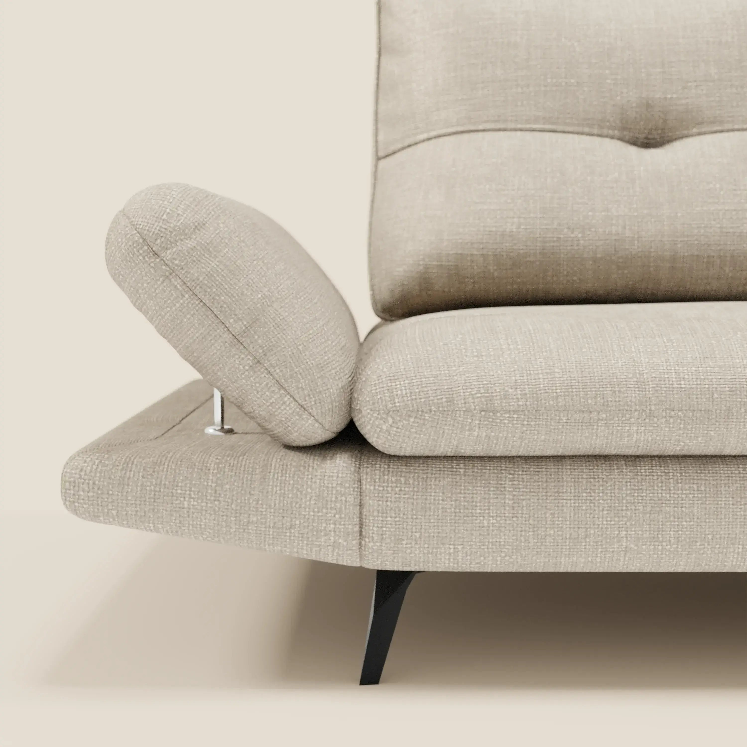 Un primo piano di Ardex Divano 3 posti di Divani.Store in tessuto impermeabile T06 panna mostra un bracciolo regolabile angolato verso l'alto, schienali traslanti, cuscino trapuntato, gambe nere in metallo e design contemporaneo su sfondo crema.