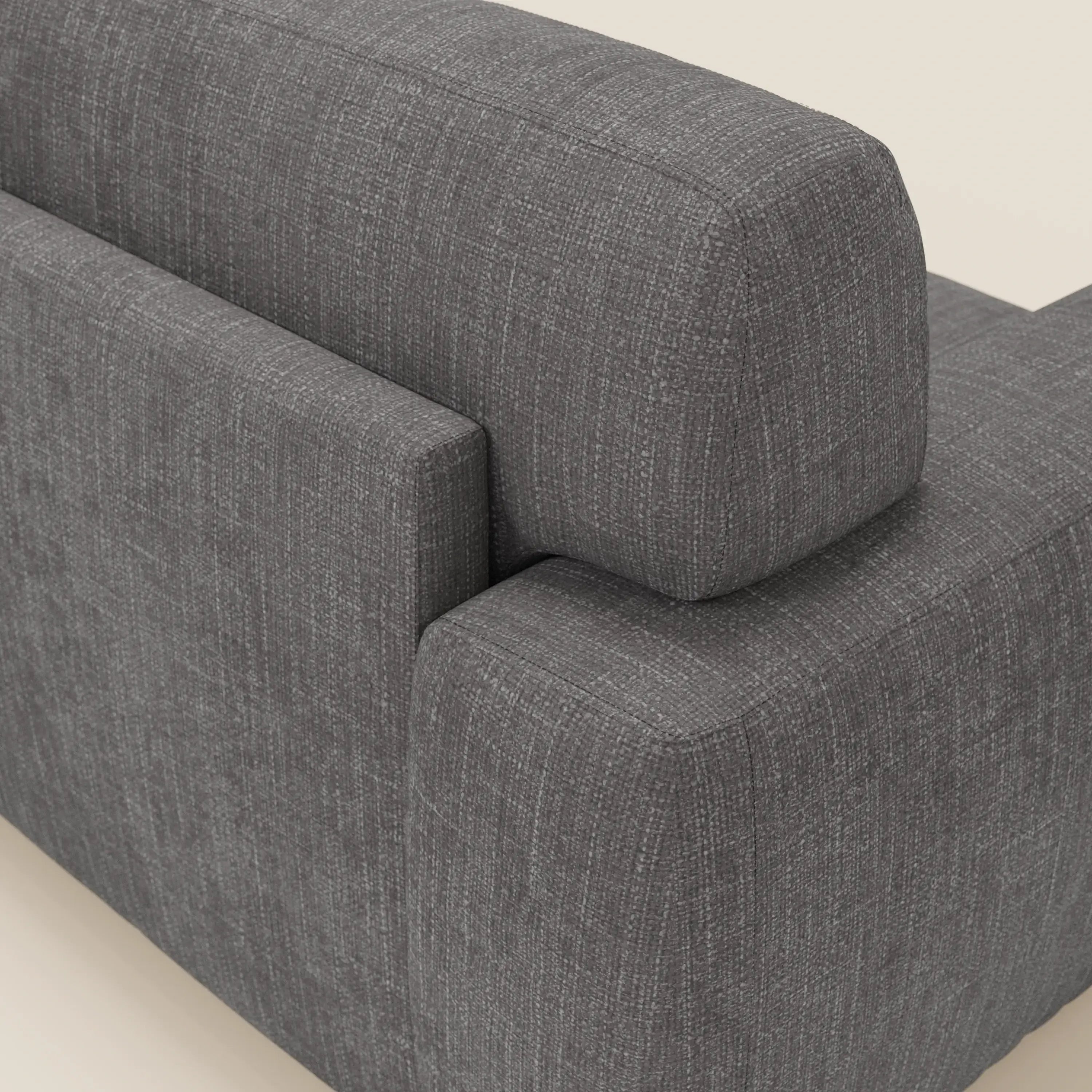 Primo piano del letto materasso Cloud Divano H17 cm di Divani.Store in tessuto impermeabile T06 antracite, che evidenzia il punto di incontro tra il bracciolo e lo schienale e mostra il suo design compatto con rivestimento a trama sottile su un pavimento chiaro.