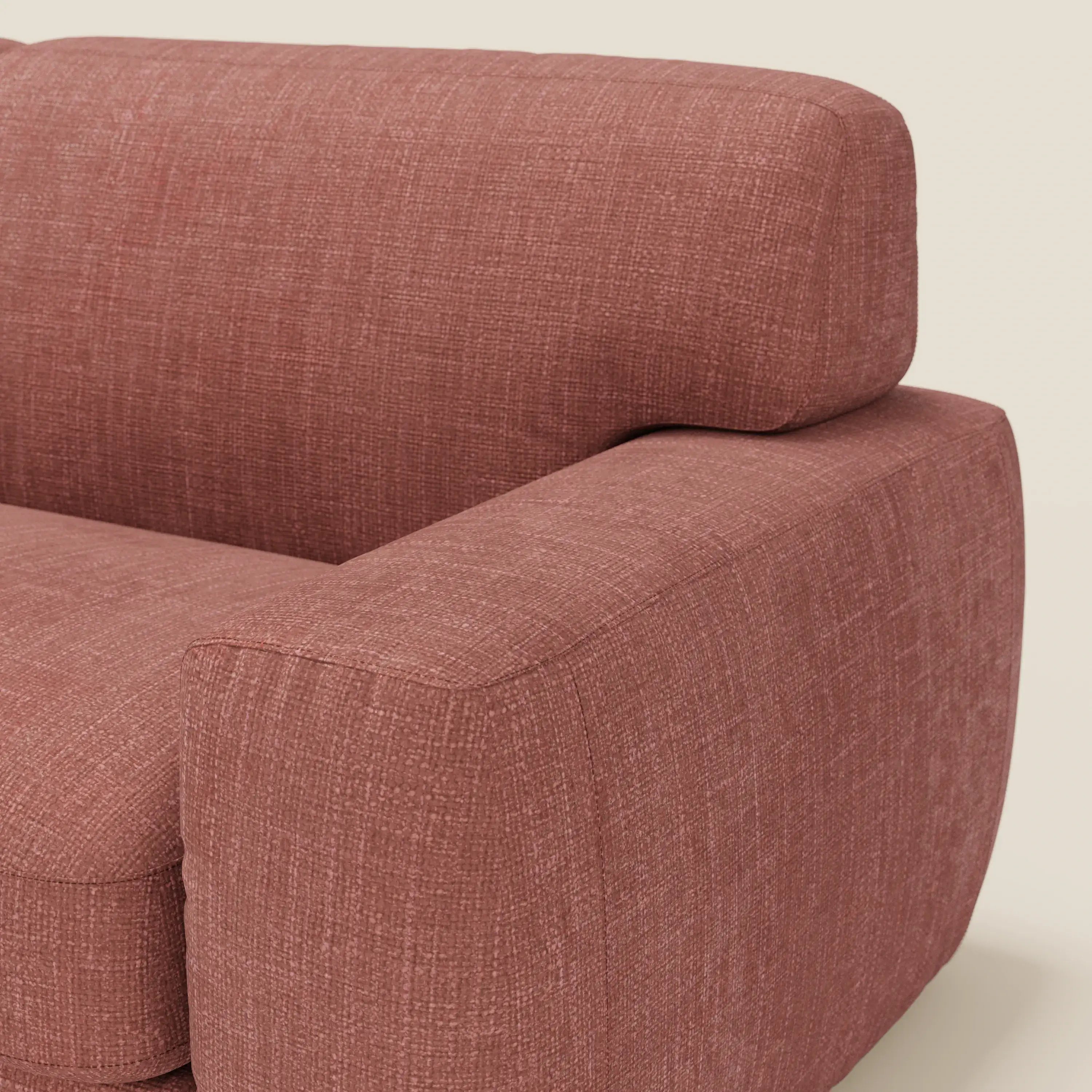 Primo piano del letto materasso Cloud Divano H17 cm di Divani.Store, con morbidi cuscini in tessuto impermeabile T06 corallo, caratterizzato da ampi braccioli squadrati e da uno spesso schienale rettangolare su sfondo beige chiaro.