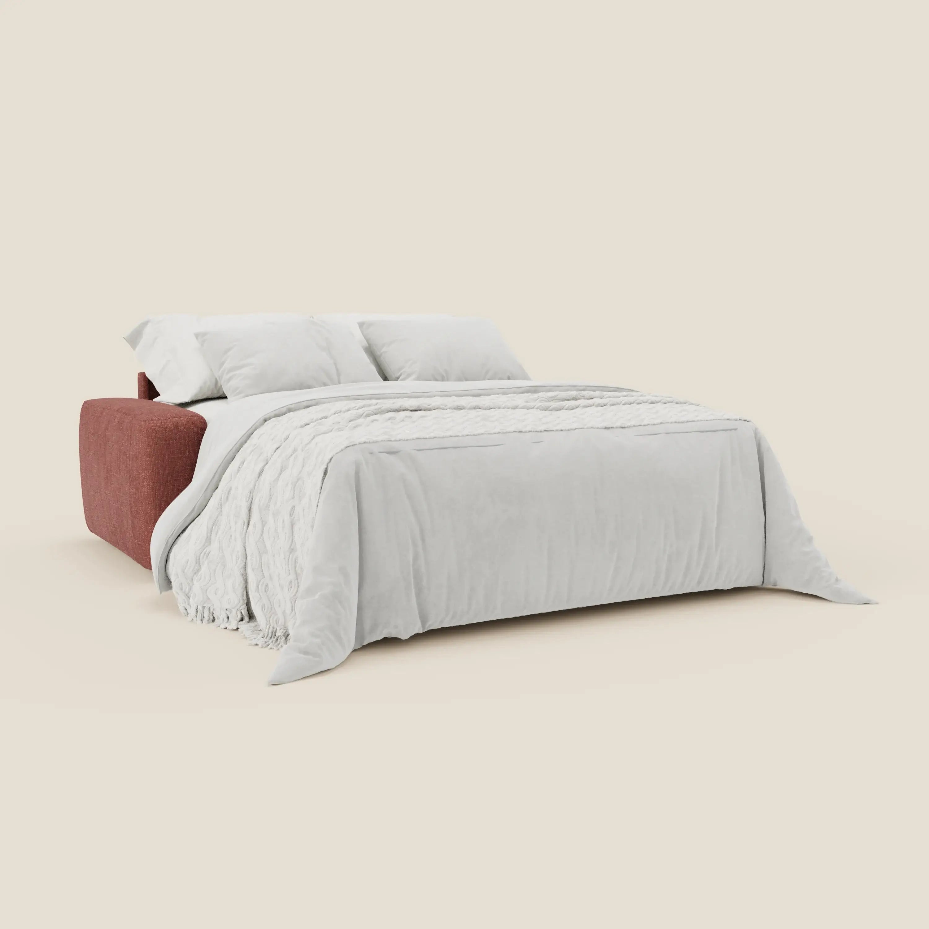 Il letto materasso Cloud Divano H17 cm di Divani.Store, in tessuto impermeabile T06 corallo, si dispiega in un letto con piumone bianco, coperta testurizzata e due cuscini bianchi, su sfondo beige chiaro.