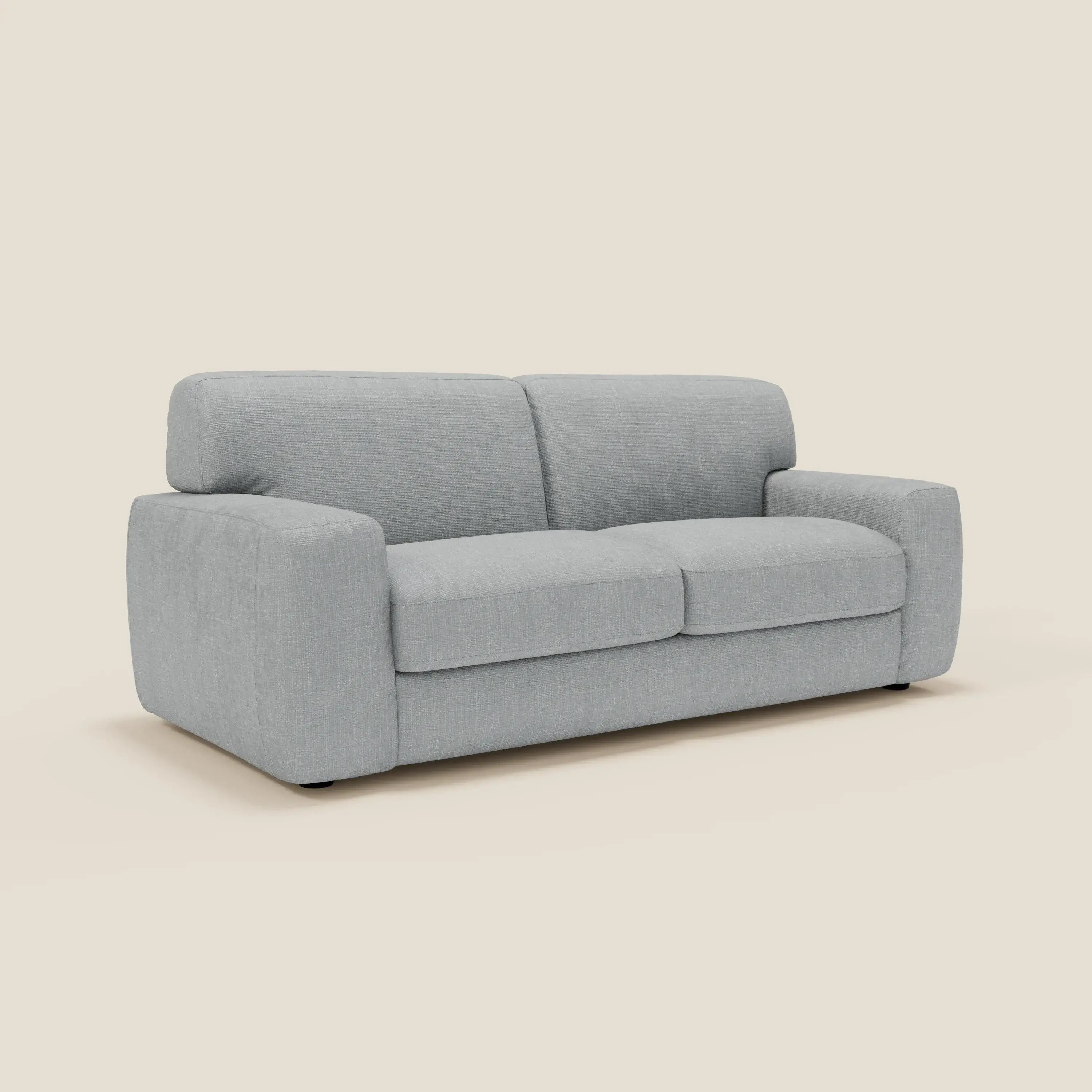 Il divano letto materasso Cloud H17 cm di Divani.Store è caratterizzato da cuscini morbidi in tessuto impermeabile T06 ghiaccio, con un design minimalista e contemporaneo e braccioli arrotondati, per ospitare comodamente due o tre persone su uno sfondo bianco sporco.