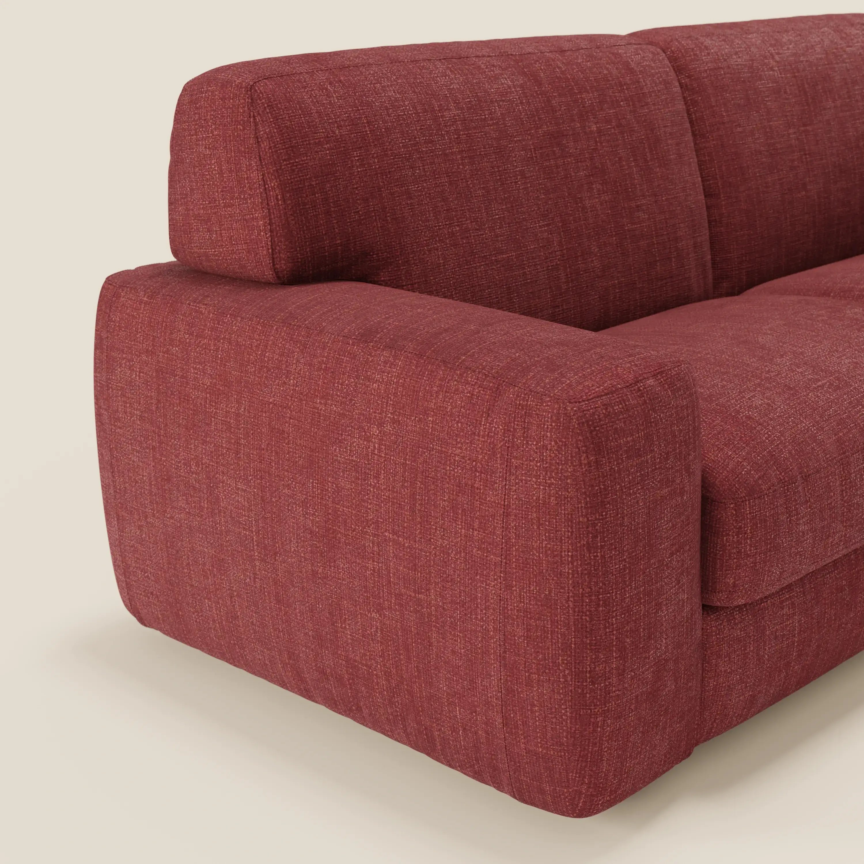 Primo piano del letto materasso Cloud Divano H17 cm di Divani.Store, caratterizzato da morbidi cuscini in tessuto impermeabile T06 rosso. L'immagine evidenzia il bracciolo, lo schienale e la seduta in peluche su uno sfondo chiaro e neutro.