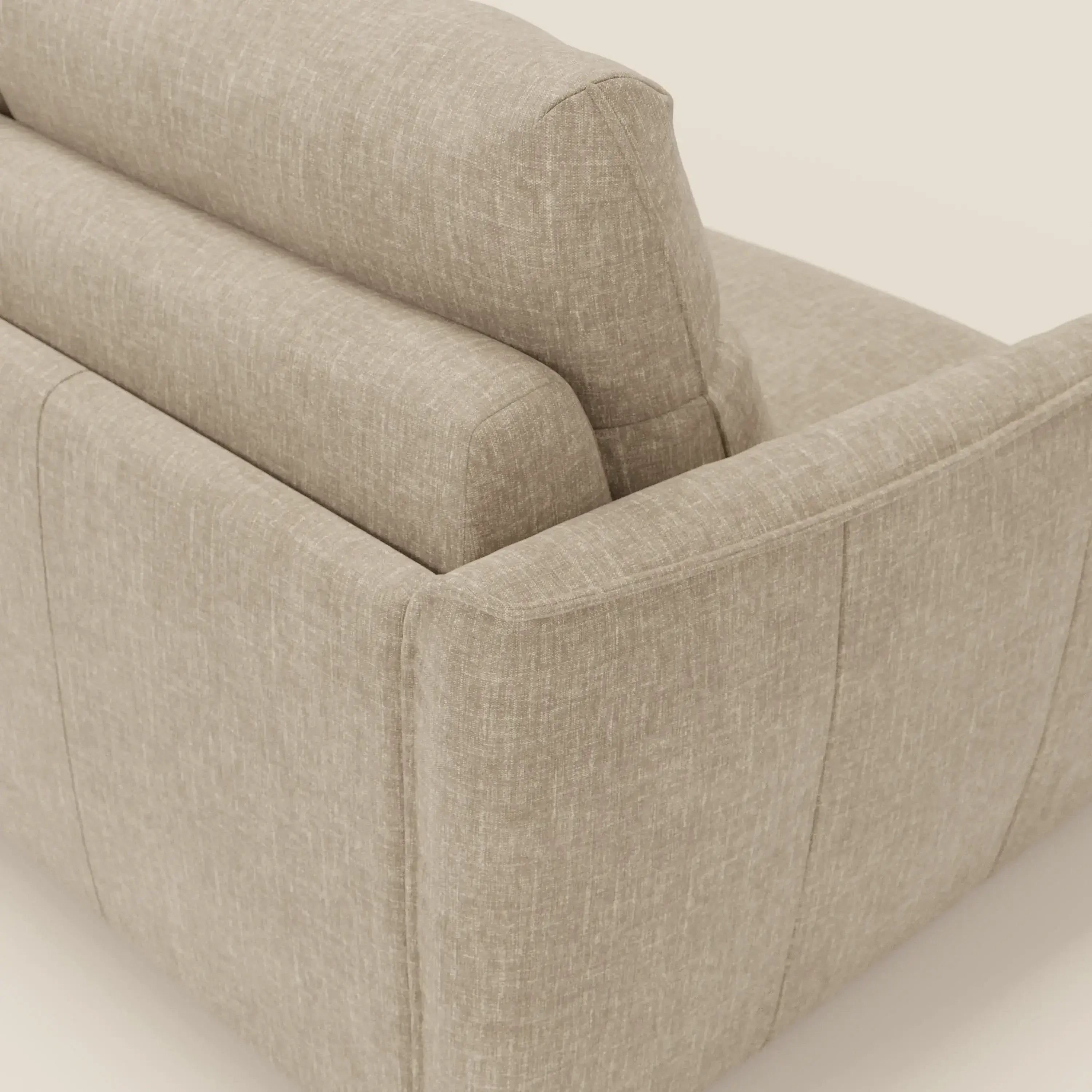 Primo piano del divano letto beige Elios Divano con morbidi cuscini spalliera in tessuto smacchiabile T24 di Divani.Store, che mostra il suo tessuto strutturato, i cuscini morbidi e le linee moderne su uno sfondo semplice.