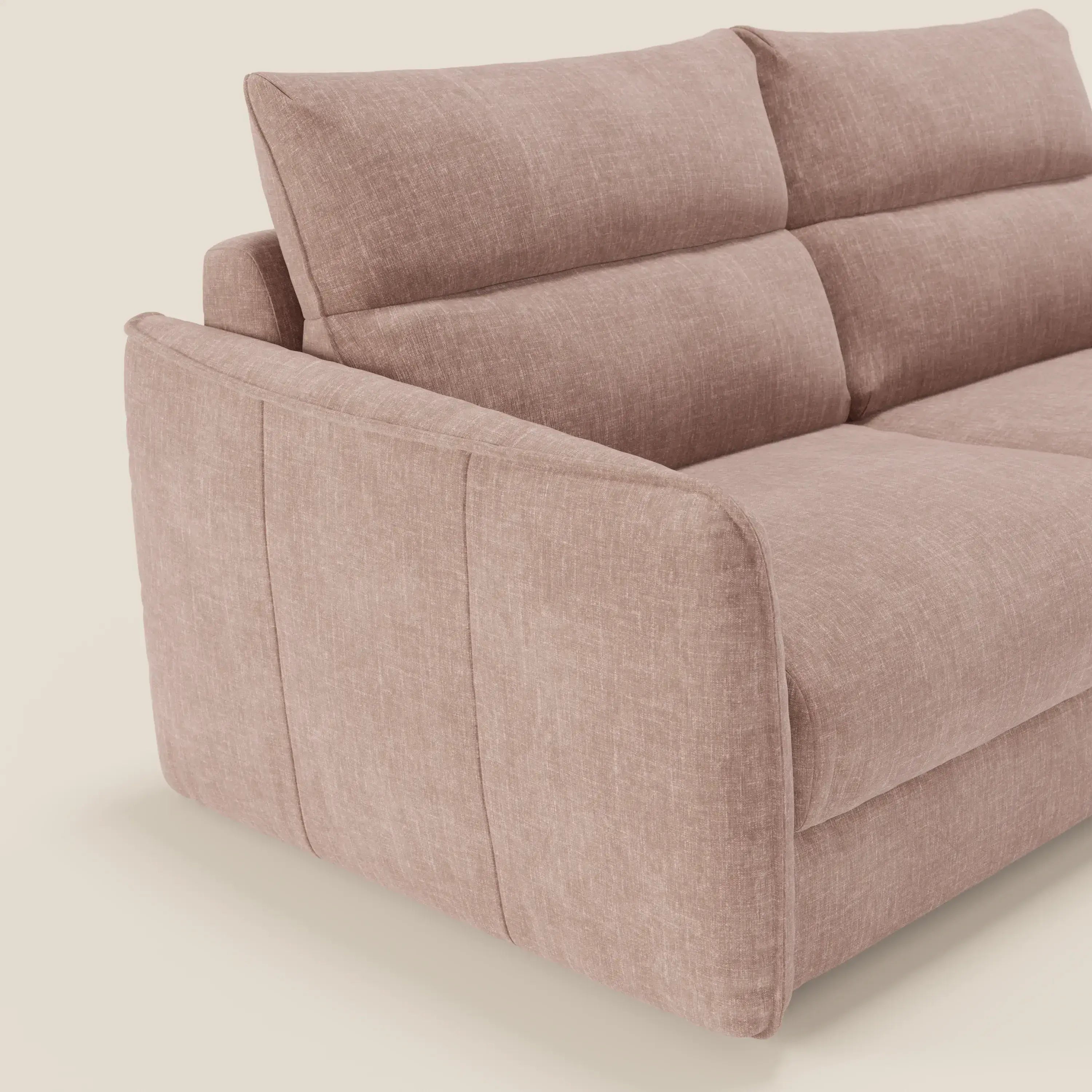Primo piano di Elios Divano letto di Divani.Store, caratterizzato da morbidi cuscini di schienale in tessuto antimacchia rosa cipria T24, ampi braccioli in tessuto felpato, schienali imbottiti e dettagli di cucitura a vista su uno sfondo neutro.