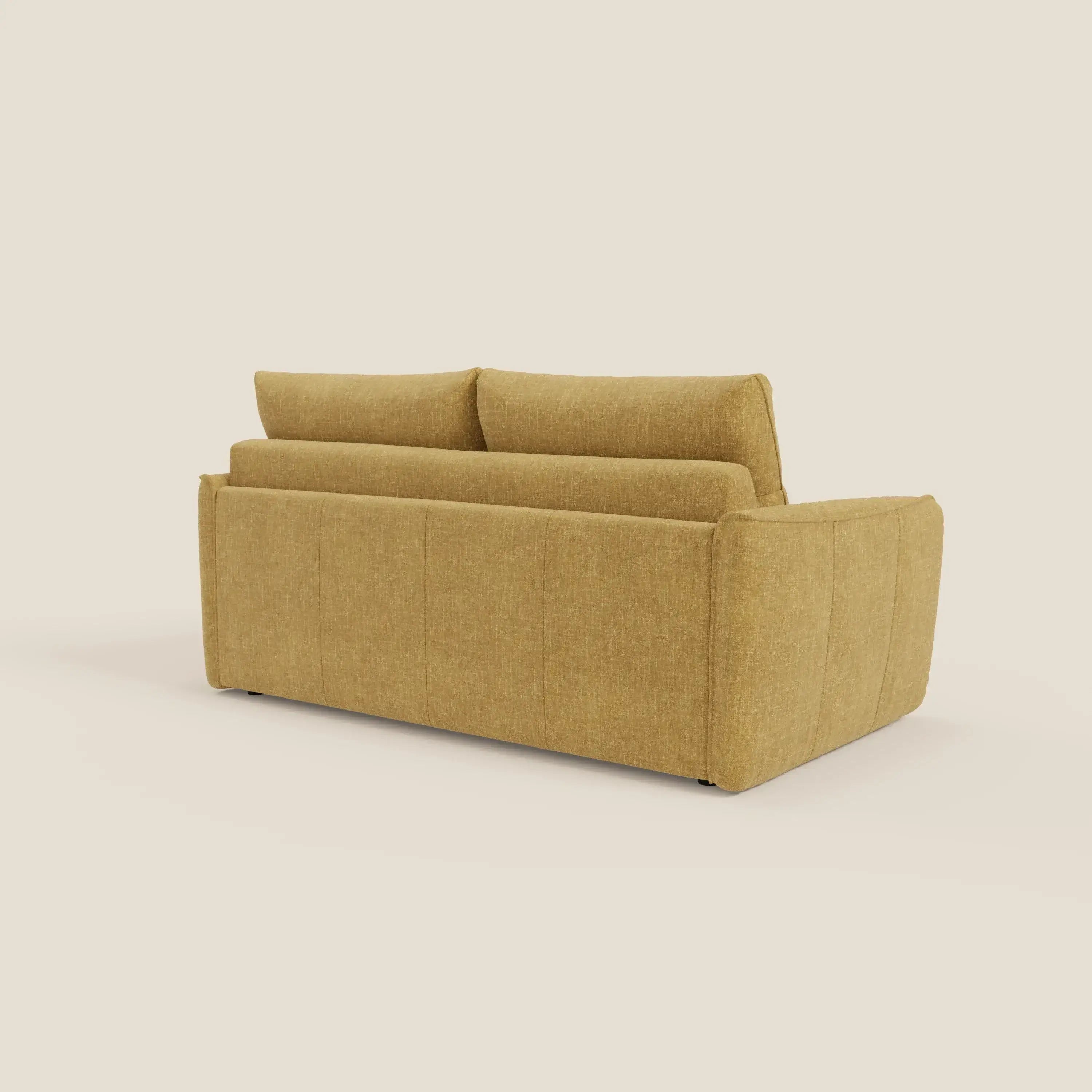 Il divano letto Elios di Divani.Store in T24 giallo si presenta con lo schienale inclinato, i braccioli morbidi e arrotondati e i cuscini in tessuto antimacchia. Il suo design pulito e minimalista spicca su uno sfondo beige semplice.