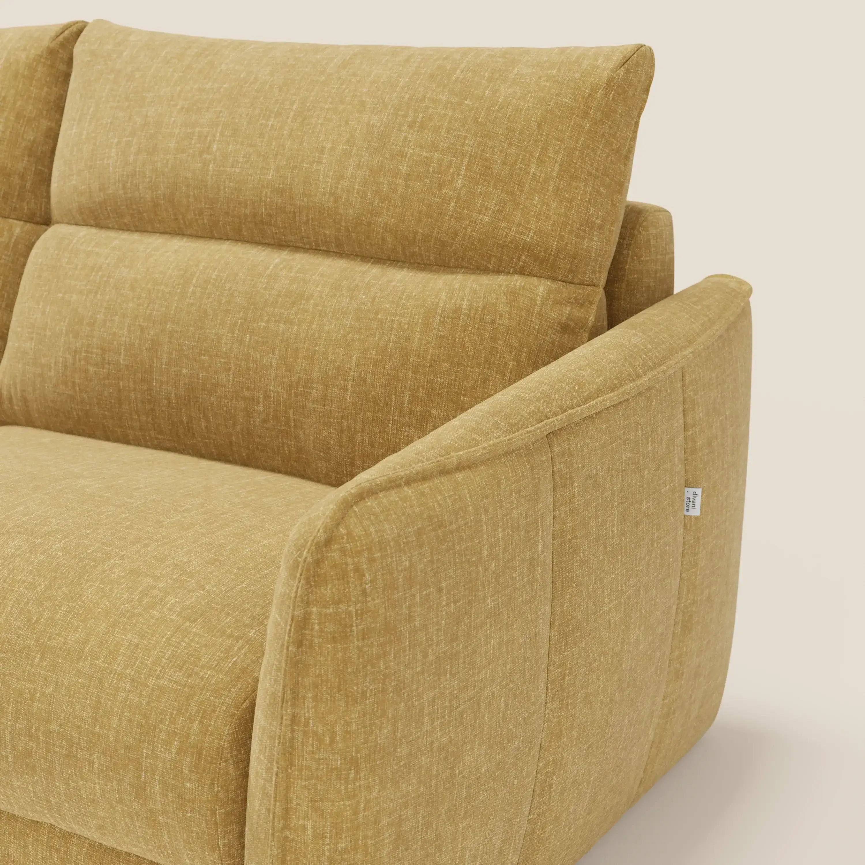 Primo piano del divano letto Elios di Divani.Store, caratterizzato da tessuto T24 giallo smacchiabile, cuscini in spalliera e bracciolo angolato. Una targhetta bianca sottolinea il design pratico su uno sfondo crema chiaro.
