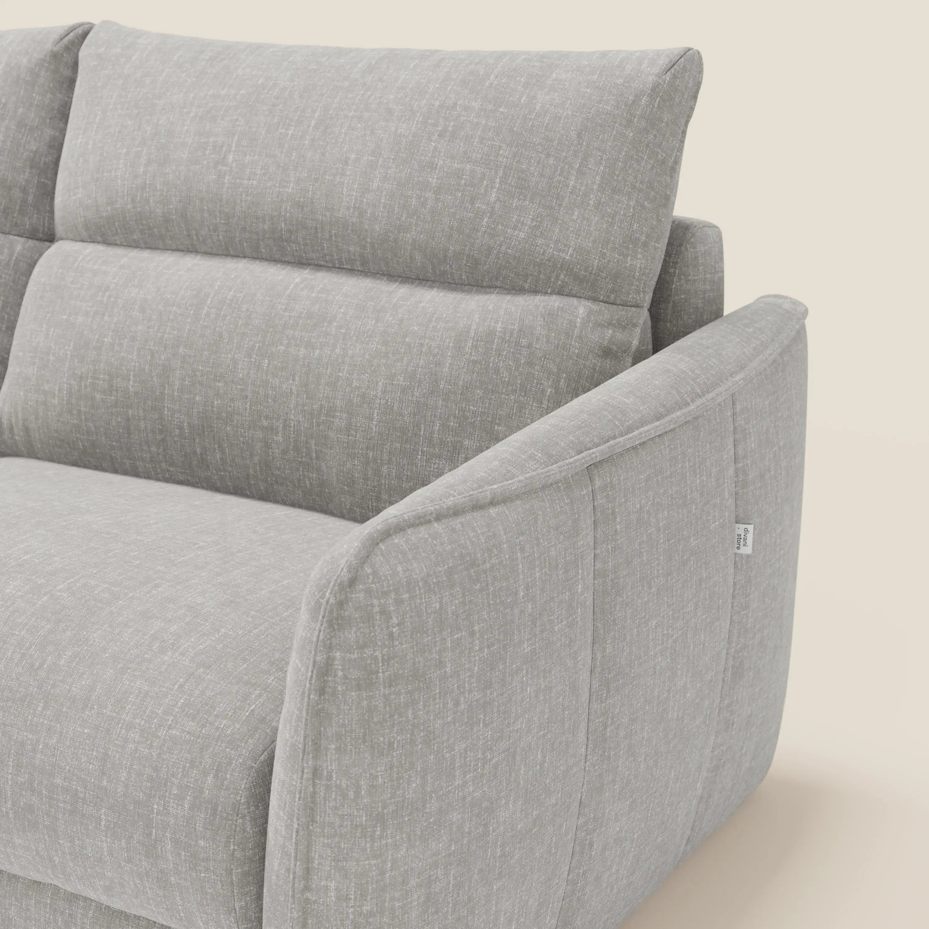 Primo piano del divano letto Elios di Divani.Store, caratterizzato da cuscini morbidi spalliera e tessuto smacchiabile T24 grigio. L'immagine evidenzia bracciolo, schienale e cuscino di seduta dalle linee pulite e dalla morbida imbottitura su uno sfondo beige.