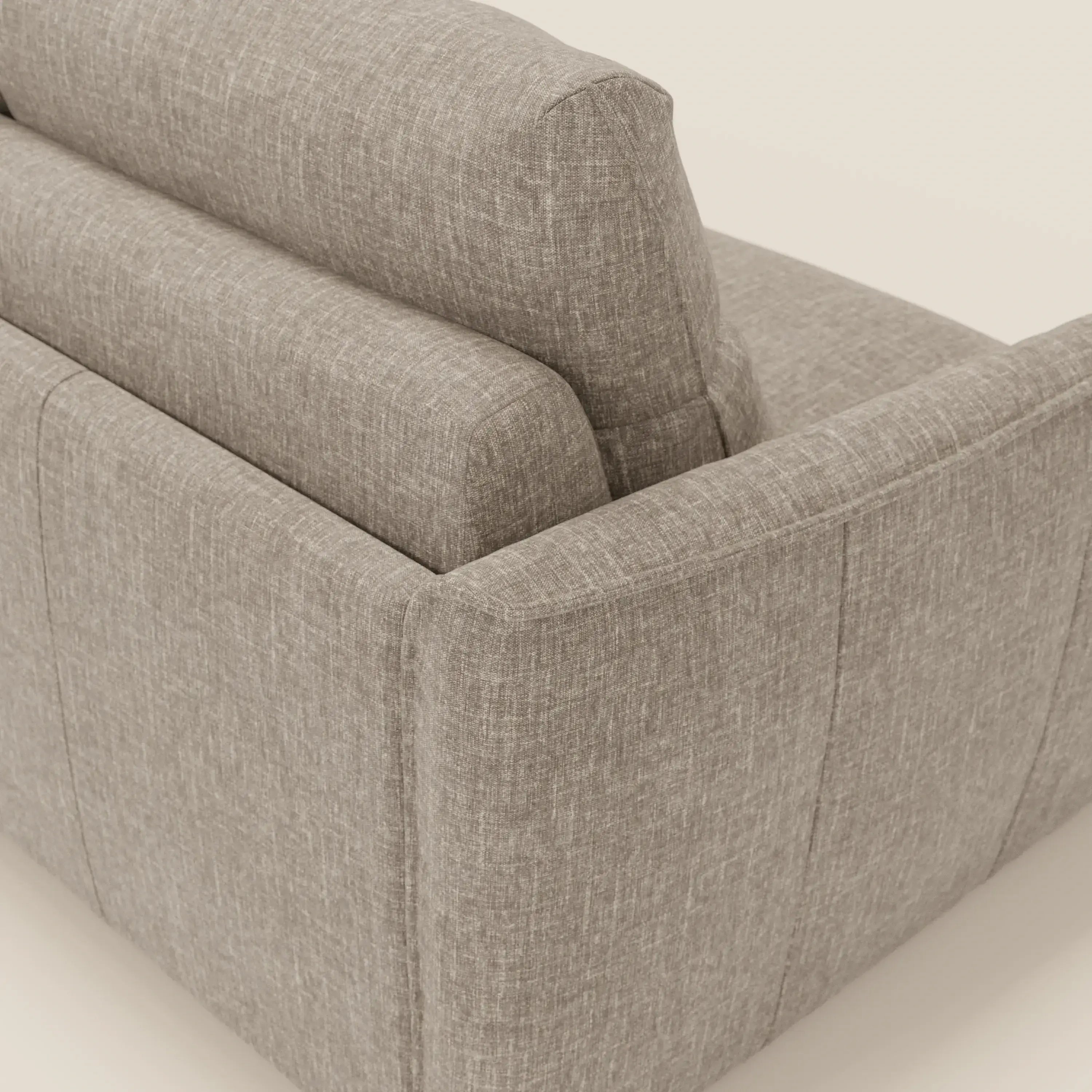 Primo piano dello schienale e del fianco del divano letto Elios di Divani.Store, caratterizzato da morbidi cuscini dello schienale impilati in tessuto smacchiabile T24 marrone tortora, ampi braccioli imbottiti e sottili cuciture a vista.