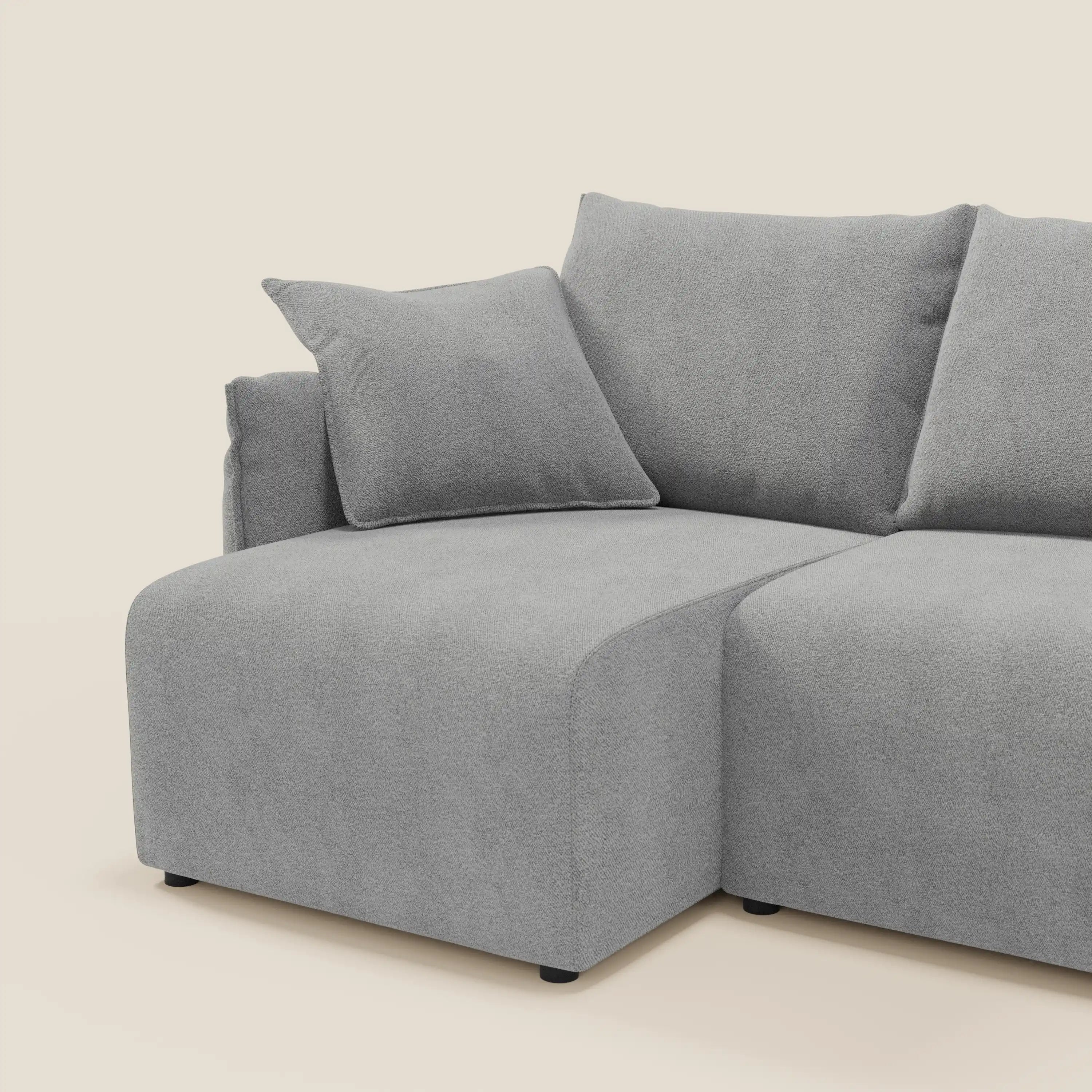 Il Flexar Divano angolare reversibile con sedute allungabili in bouclé morbido impermeabile T07 grigio di Divani.Store è presentato su uno sfondo bianco sporco, con linee pulite, cuscini morbidi, design modulare e cuscino coordinato per un look accogliente.