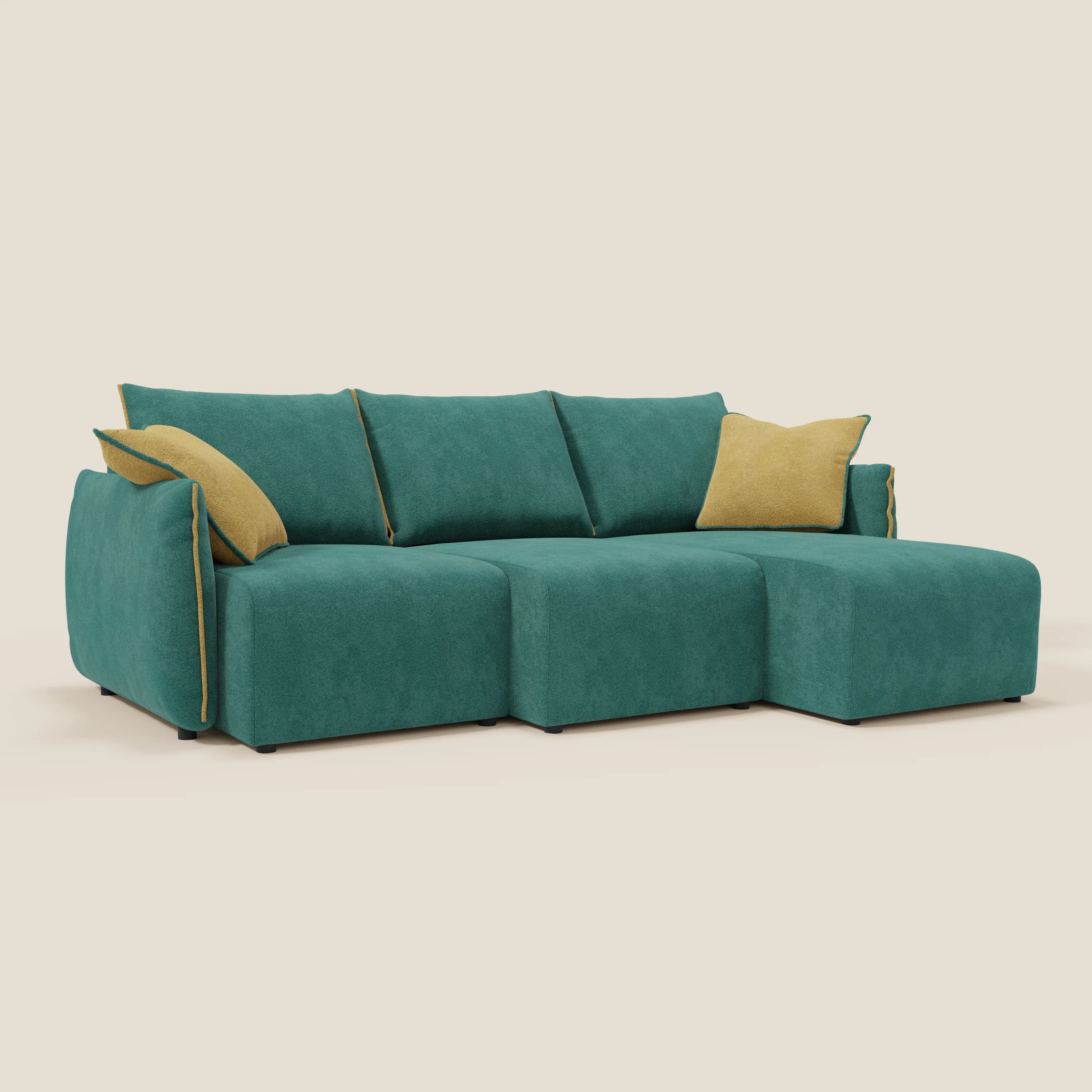 Il Divano angolare reversibile Flexar di Divani.Store è caratterizzato da sedute allungabili in bouclé impermeabile verde-giallo T07, due cuscini di stoffa senape e poggia su corte gambe nere su uno sfondo beige chiaro.