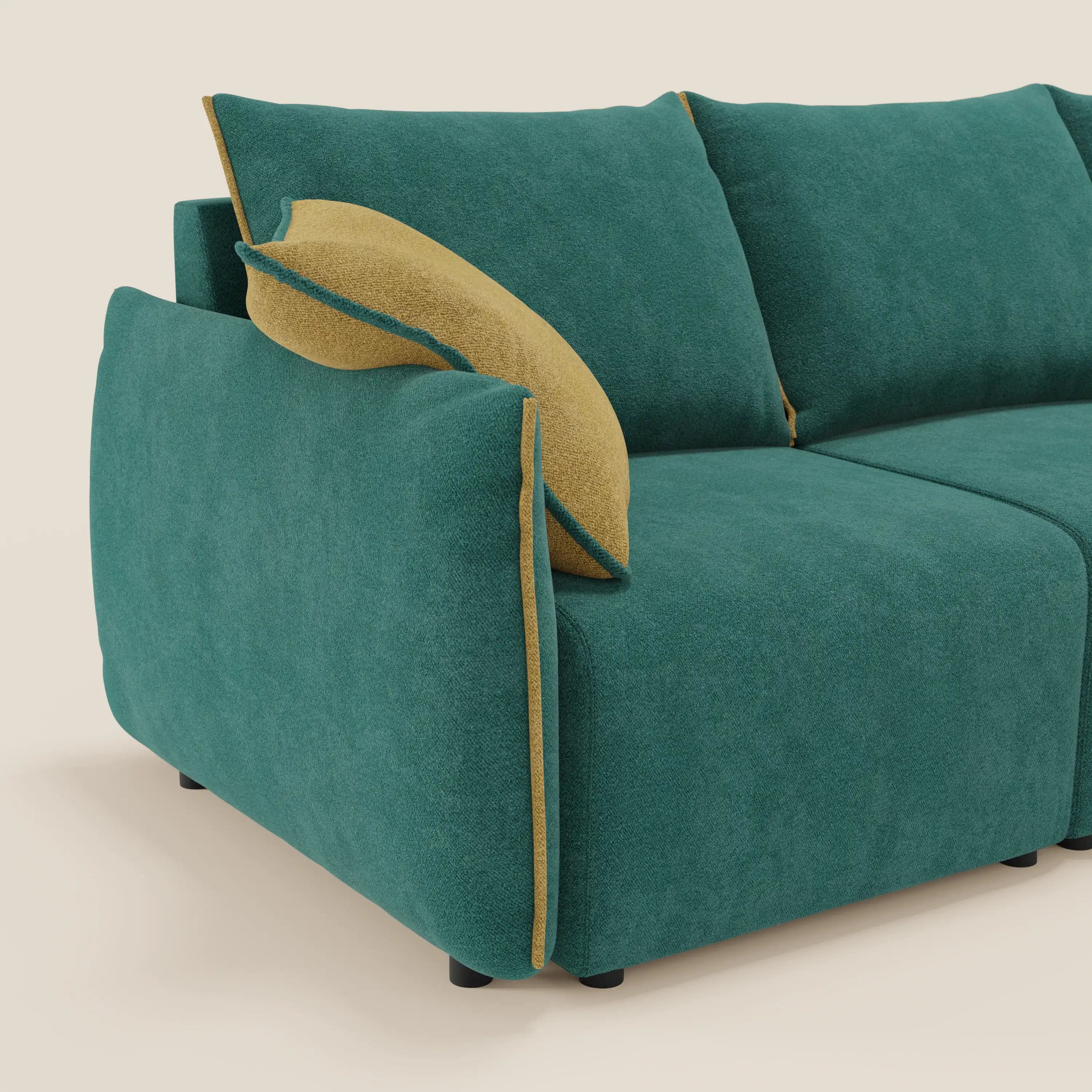 Flexar Divano angolare reversibile di Divani.Store è caratterizzato da cuscini in bouclé verde acqua con profili giallo senape e da un cuscino coordinato sul bracciolo sinistro. Le corte gambe nere sostengono il divano, su uno sfondo bianco sporco.