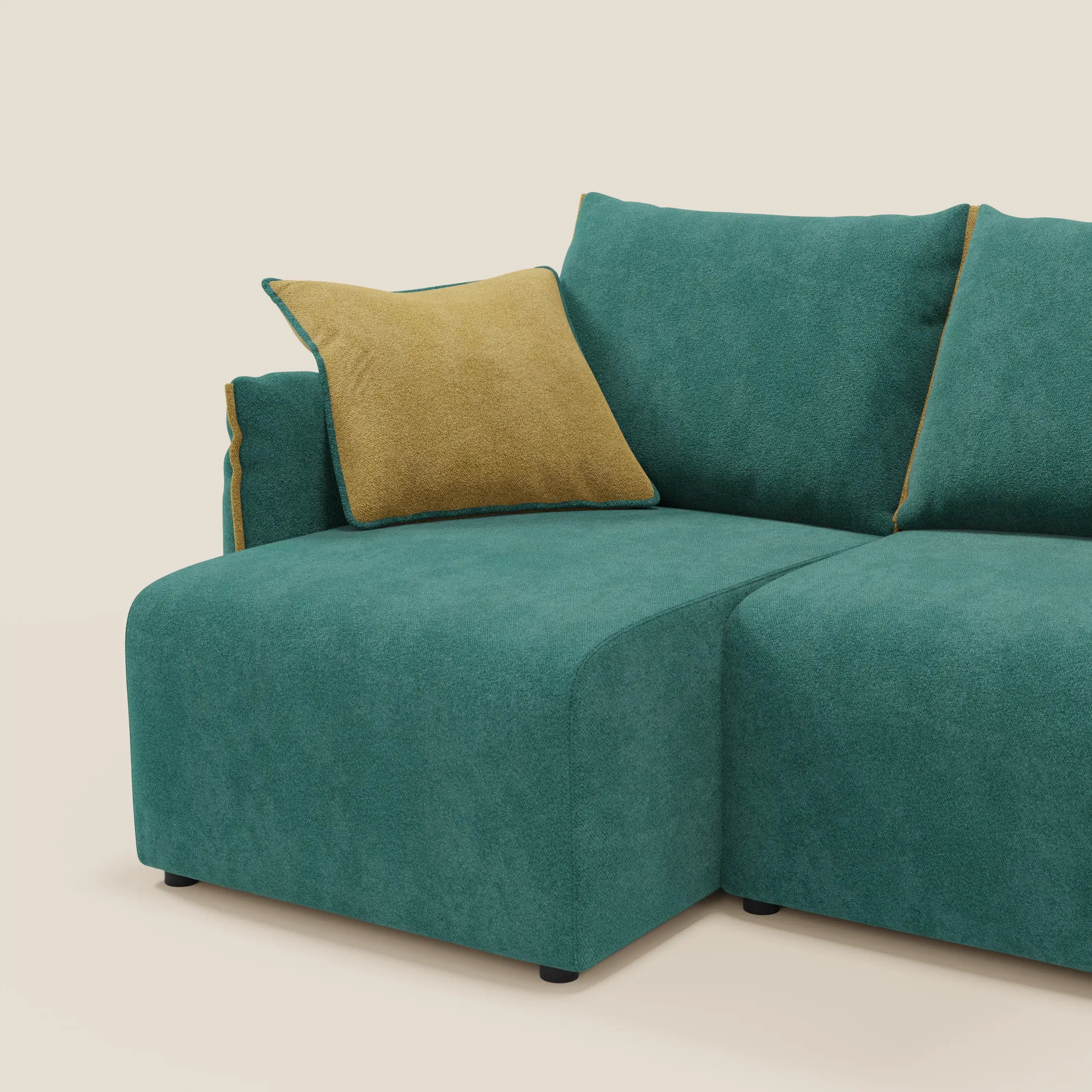 Il Divano angolare reversibile Flexar di Divani.Store è caratterizzato da sedute allungabili in morbido bouclé impermeabile T07 verde con cuscino giallo, dalle linee pulite e dallo stile moderno su uno sfondo bianco sporco.