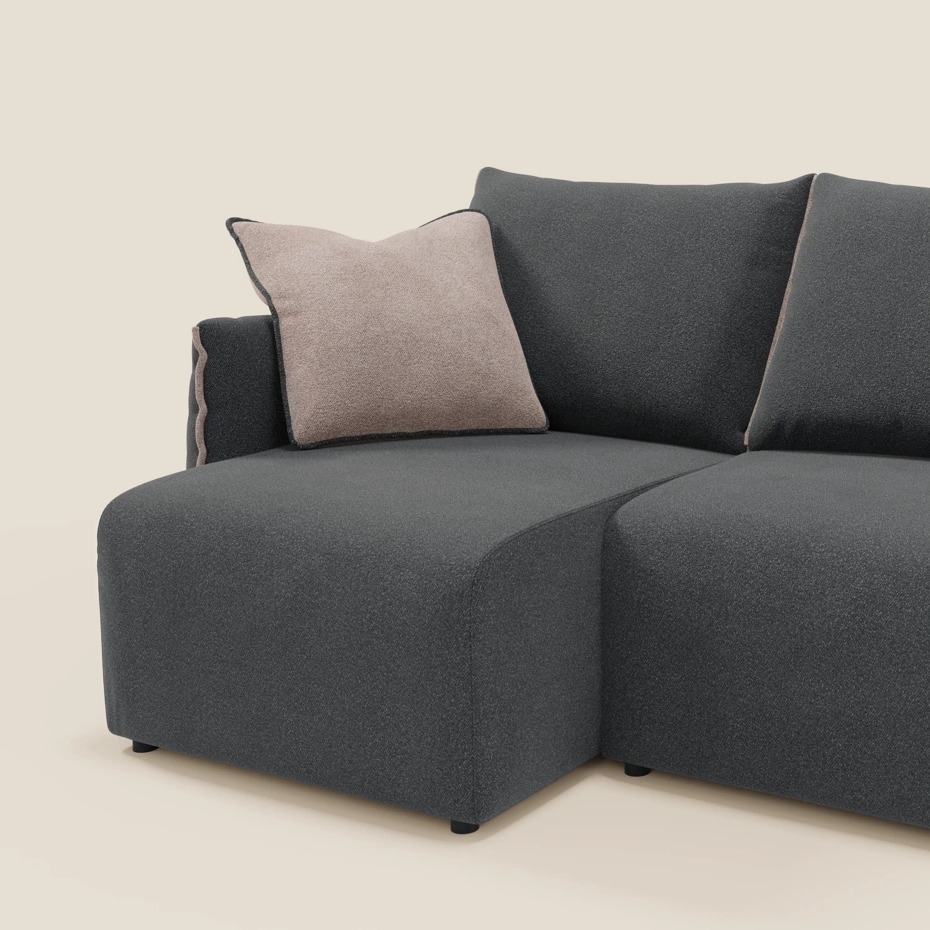 Il divano Flexar di Divani.Store, con 3 sedute allungabili e schienale in piuma d'oca in bouclé impermeabile T07 antracite-rosa, è proposto su uno sfondo beige chiaro in tinta unita, con un unico cuscino di lancio beige chiaro con profili scuri.