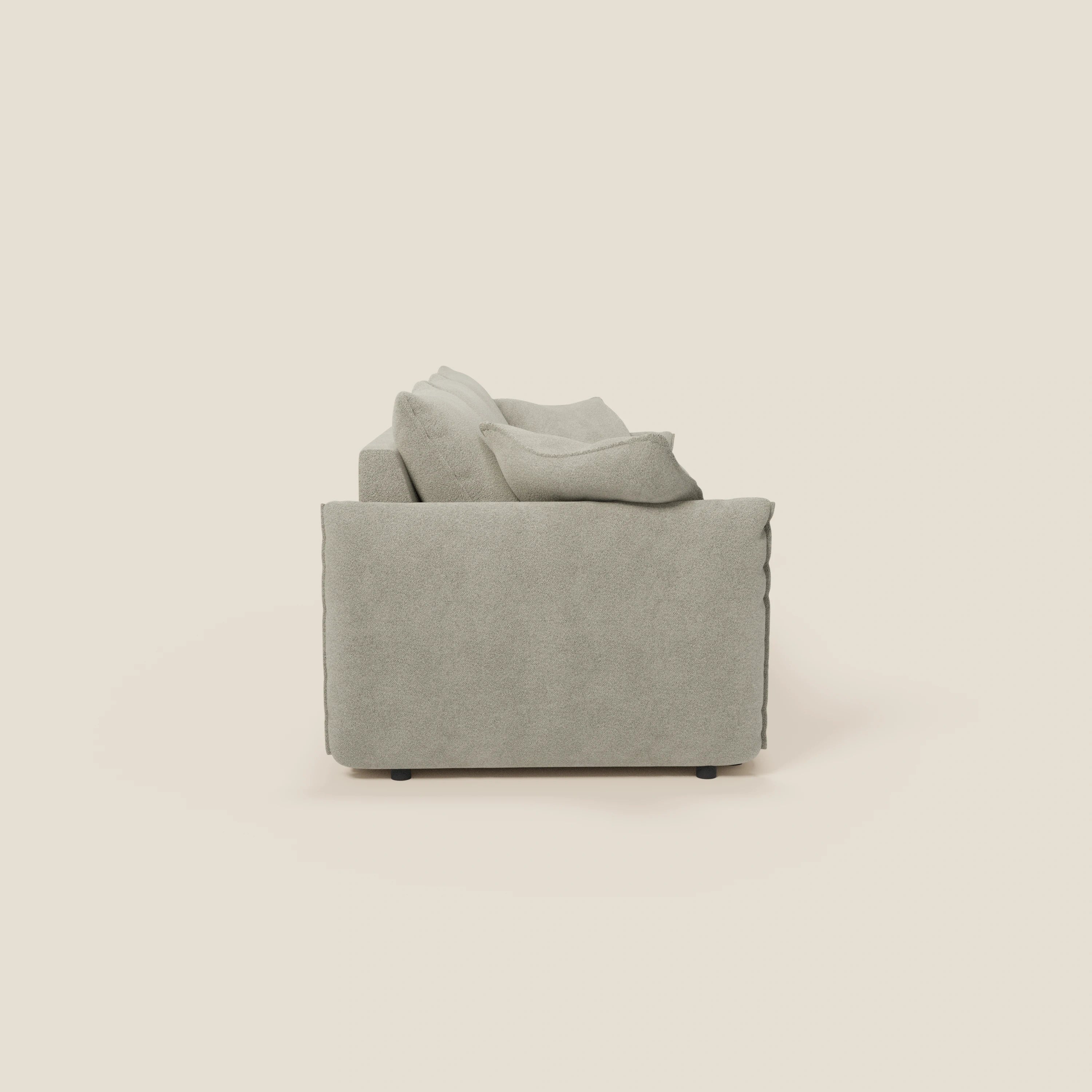 Vista laterale del divano Flexar con 3 sedute allungabili di Divani.Store, in bouclé impermeabile T07 beige e schienale in piuma d'oca, dalla forma squadrata con braccioli morbidi e piedini scuri, presentato su uno sfondo bianco sporco.