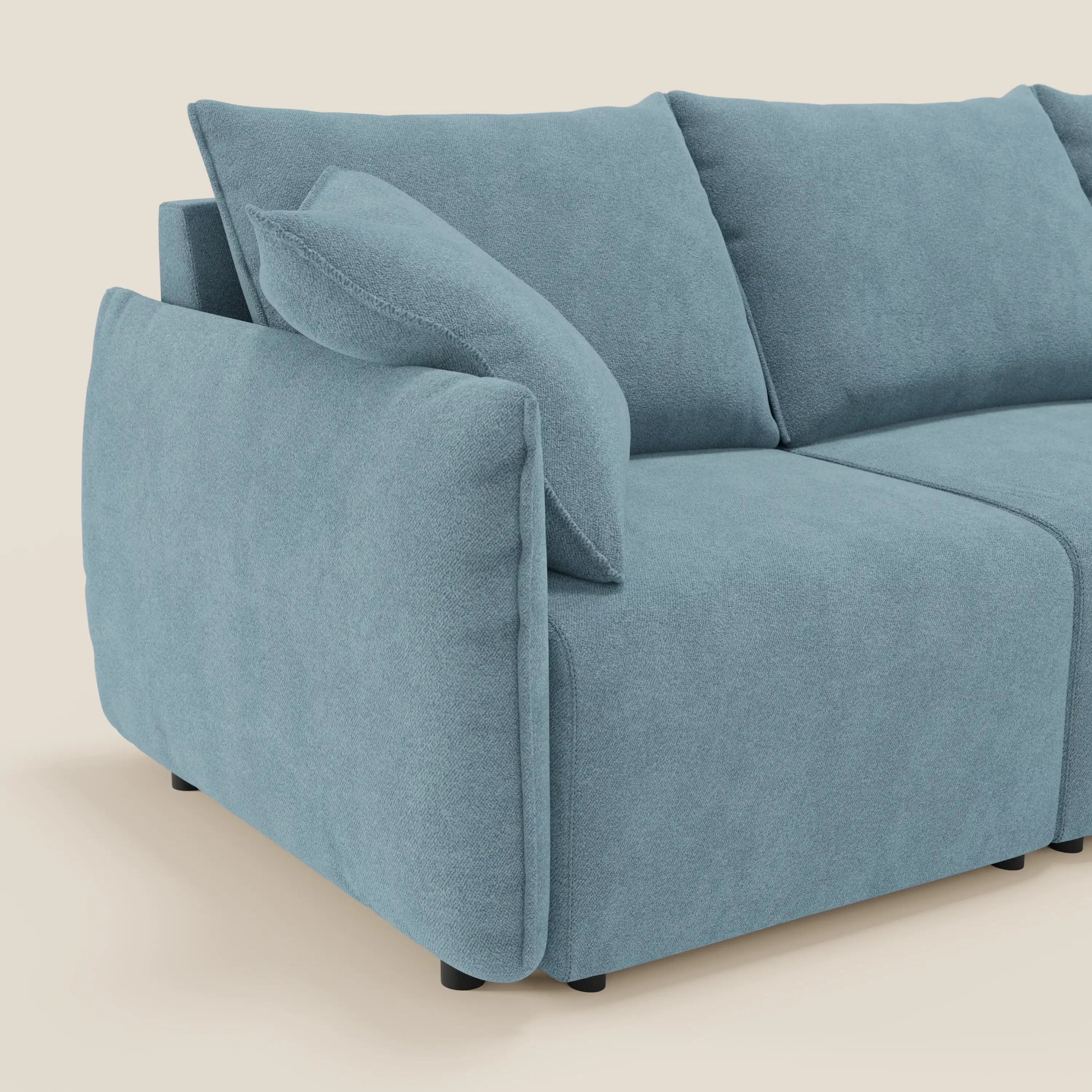 Un moderno divano Flexar con 3 sedute allungabili di Divani.Store in T07 carta da zucchero bouclé è presentato su uno sfondo crema, con schienale in piuma d'oca, cuscini coordinati e gambe corte nere.