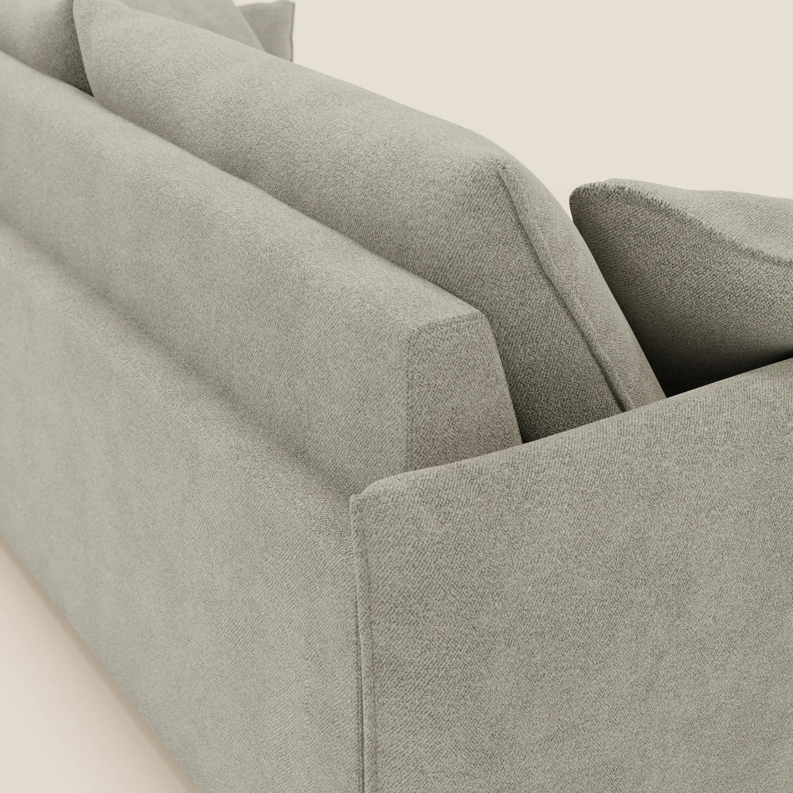 Un primo piano del divano Flexar con sedute allungabili di Divani.Store, caratterizzato da uno schienale in piuma e da un morbido rivestimento in bouclé impermeabile beige T07. L'immagine ne evidenzia la consistenza, le linee pulite e i cuscini di schienale in evidenza su uno sfondo beige.