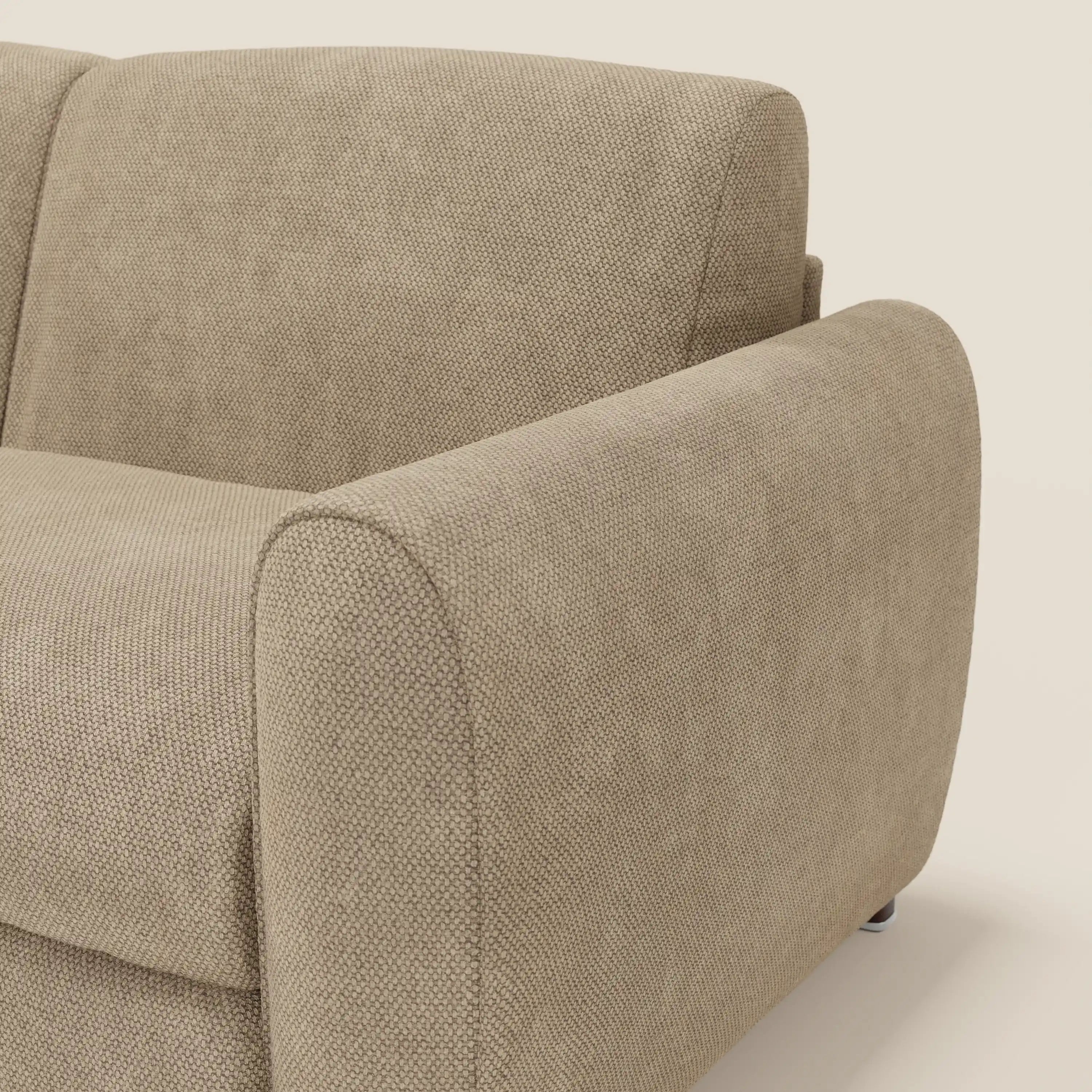 Primo piano di Kaleo Divano letto moderno di Divani.Store in tessuto impermeabile T26 beige, che mostra l'ampio bracciolo arrotondato, lo schienale imbottito, il rivestimento testurizzato e le eleganti gambe in metallo su uno sfondo semplice.