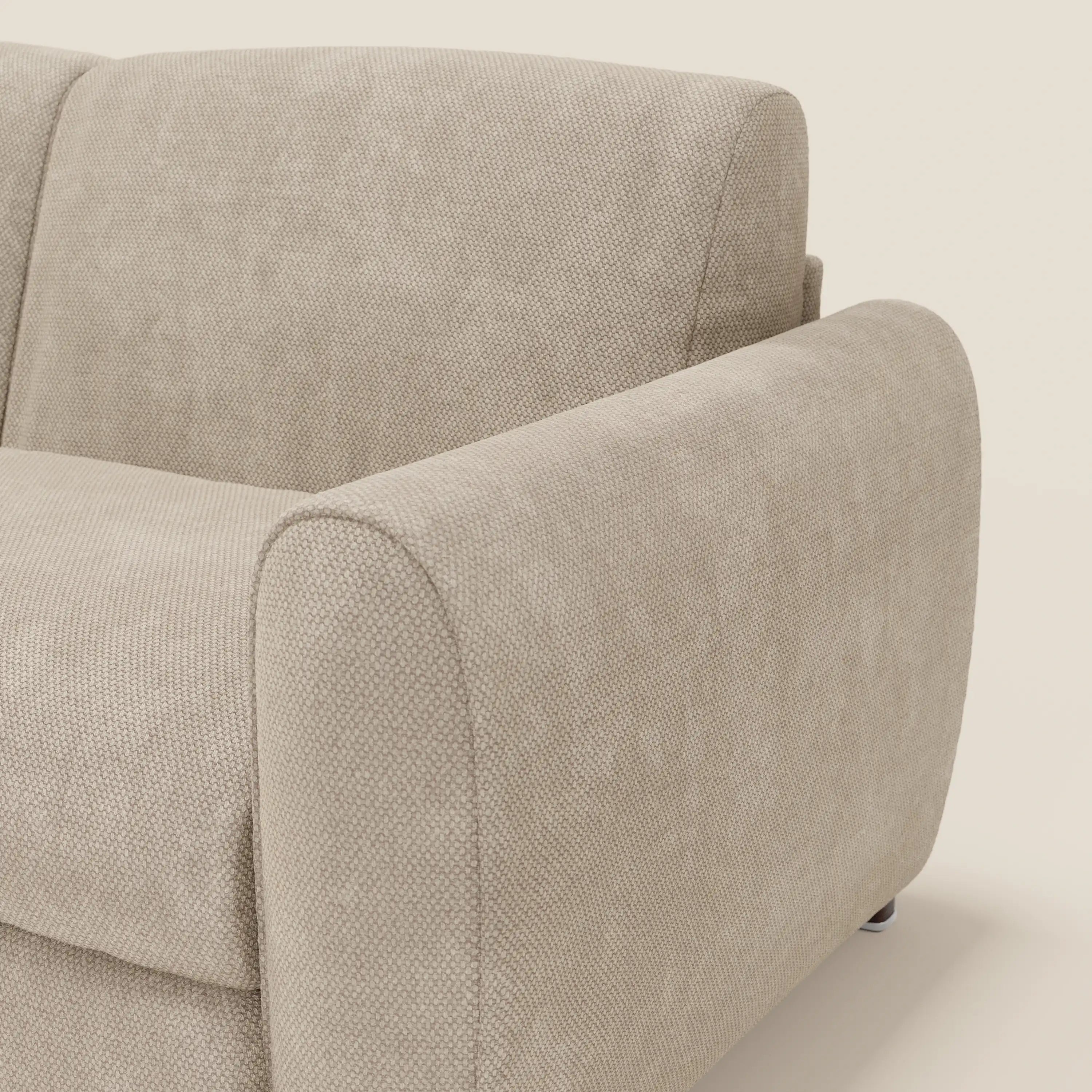 Primo piano del divano letto moderno Kaleo di Divani.Store in tessuto impermeabile T26 panna, caratterizzato da bracciolo arrotondato, imbottitura testurizzata, materasso H17 cm ad alta densità e design minimalista su sfondo tinta unita.