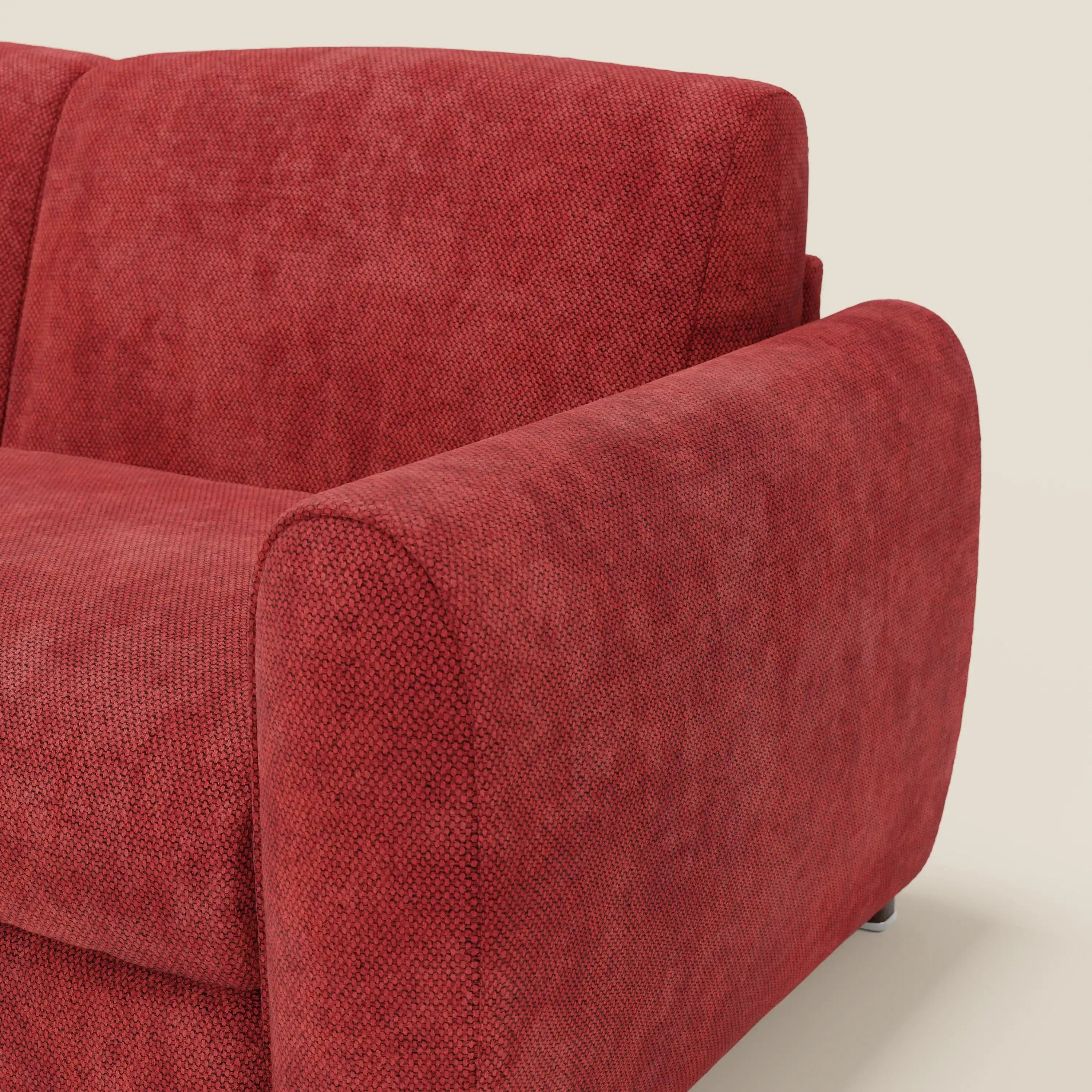 Primo piano del lato destro di Kaleo divano letto moderno di Divani.Store, rivestito in raffinato tessuto impermeabile T26 rosso vivo, con bracciolo, seduta e schienale arrotondati. Uno sfondo chiaro mette in risalto il suo colore vivace e il suo design moderno.