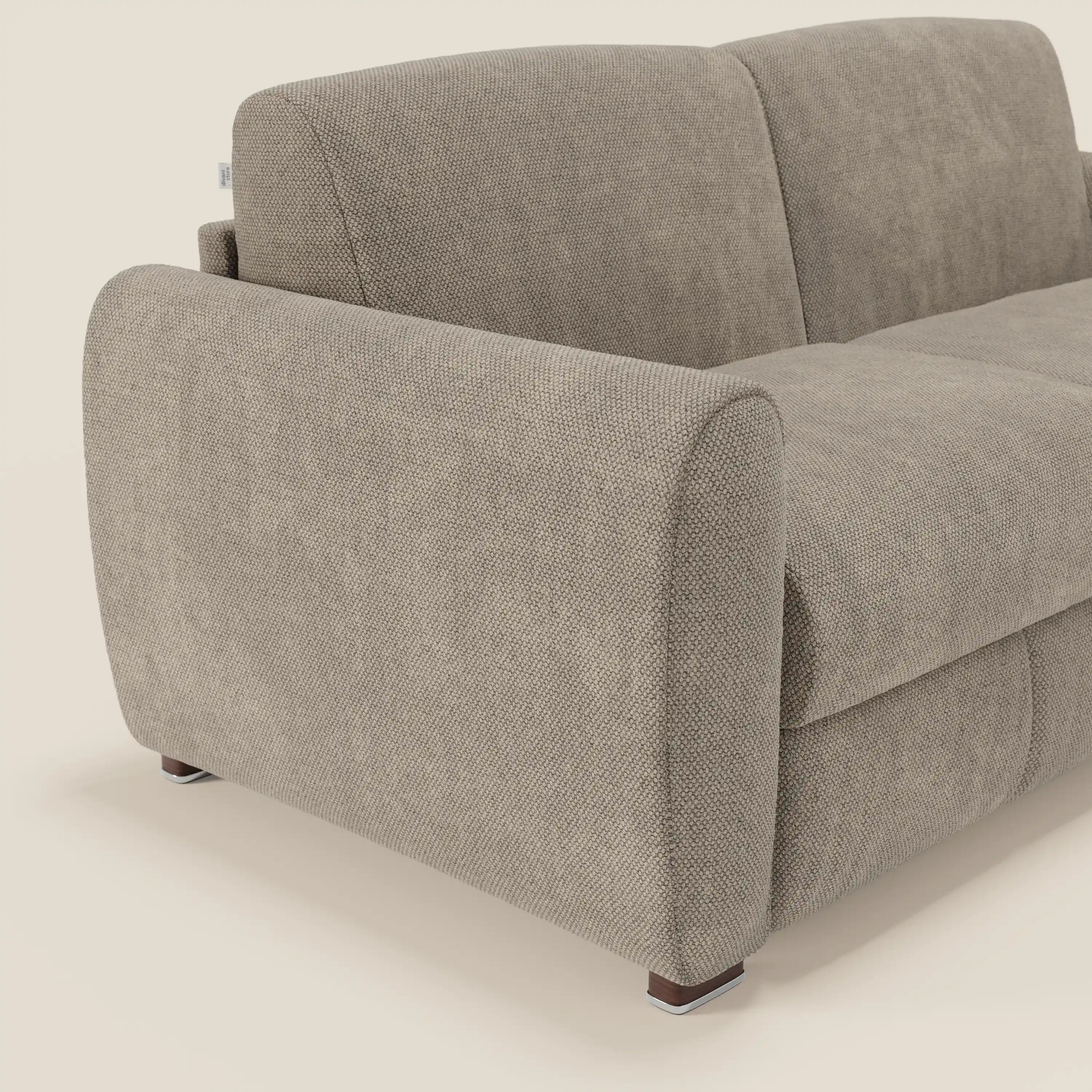 Primo piano del divano letto moderno Kaleo di Divani.Store in tessuto impermeabile T26 tortora, caratterizzato da ampi braccioli arrotondati, gambe in legno scuro e materasso di 17 cm ad alta densità per un look minimalista e contemporaneo.