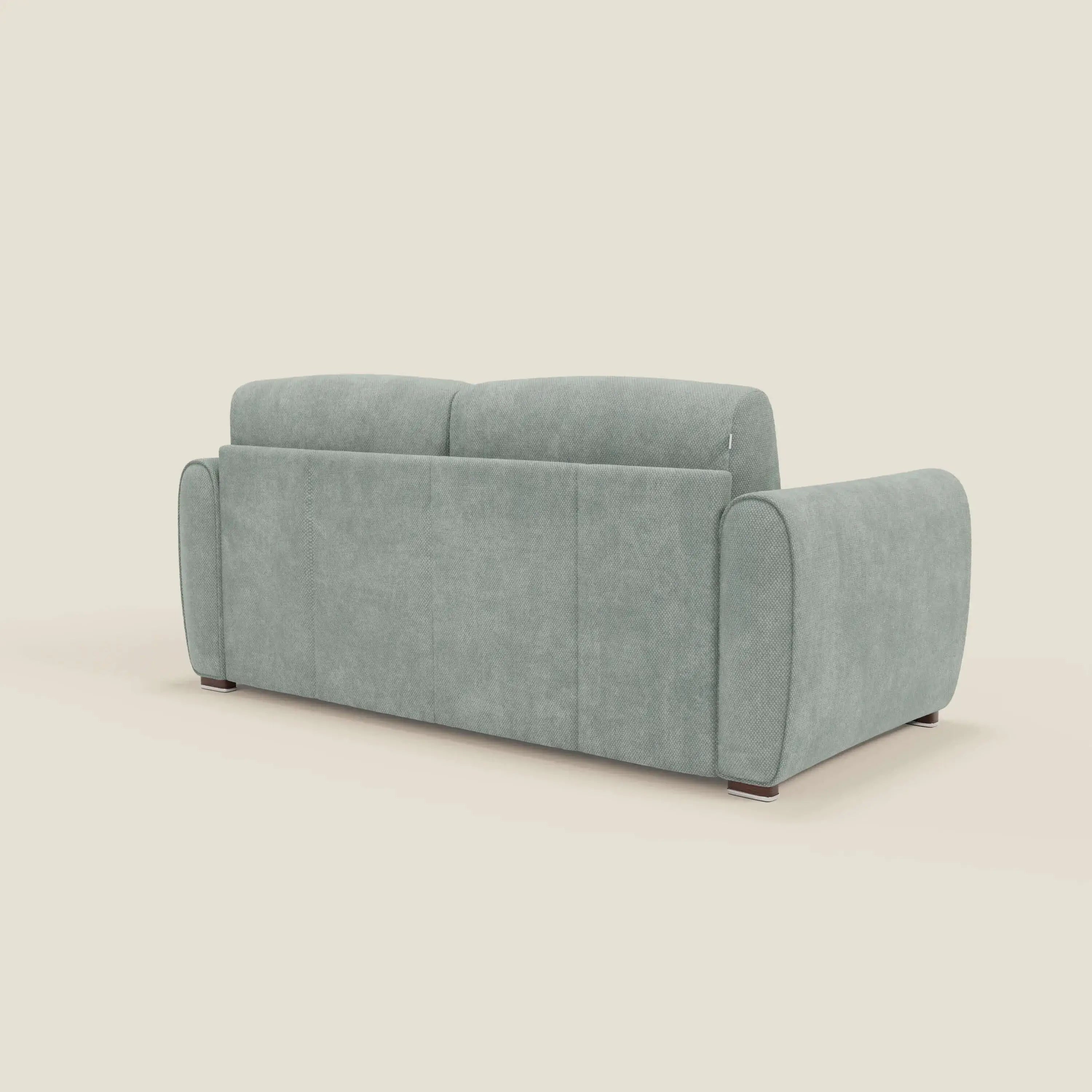 Il Kaleo Divano letto moderno di Divani.Store, in raffinato tessuto impermeabile T26 verde acqua, è caratterizzato da braccioli arrotondati, schienale alto e gambe corte e scure. Il suo design minimalista e moderno spicca su uno sfondo bianco sporco.